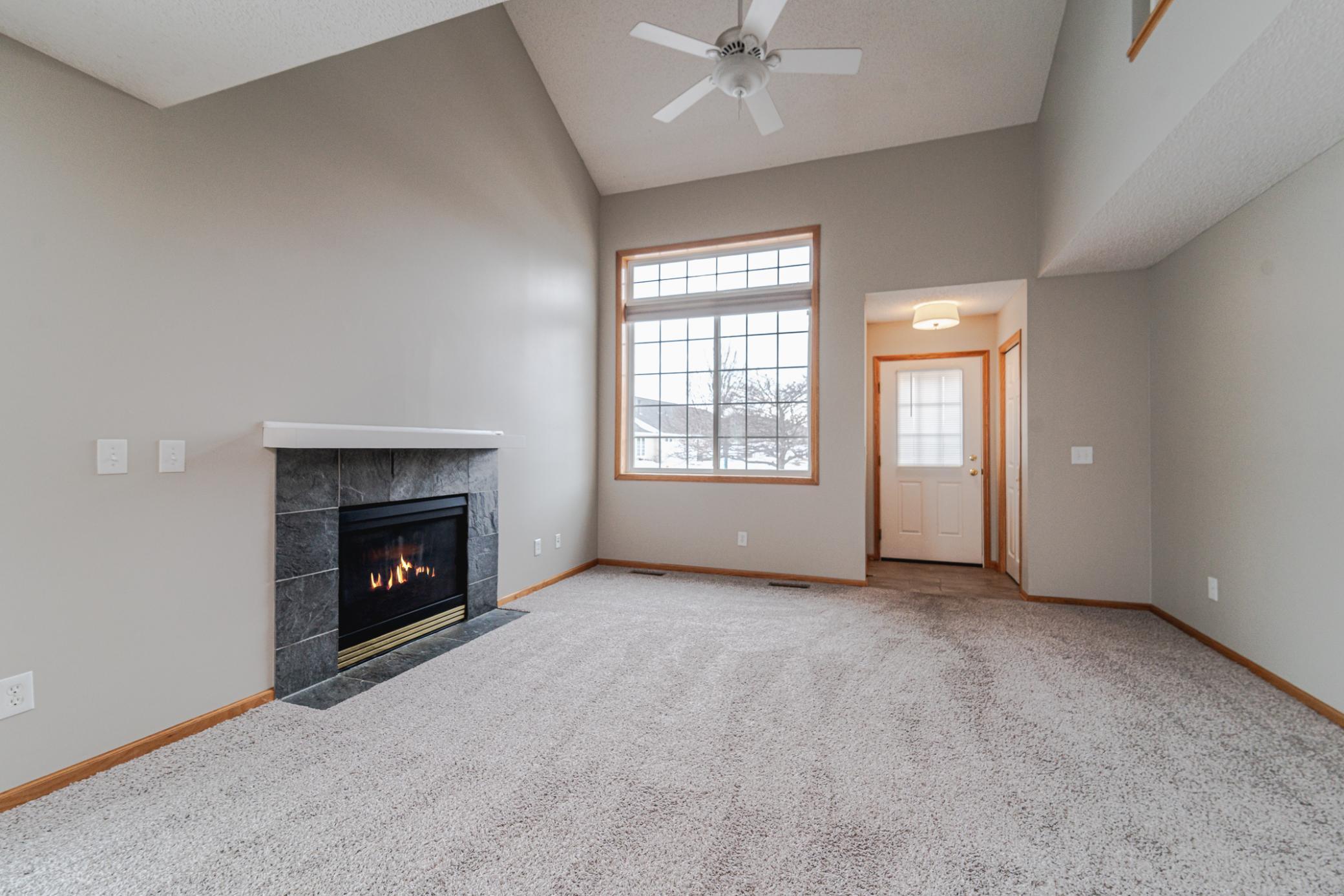 The living room has a gas fireplace and vaulted ceiling with a fan.