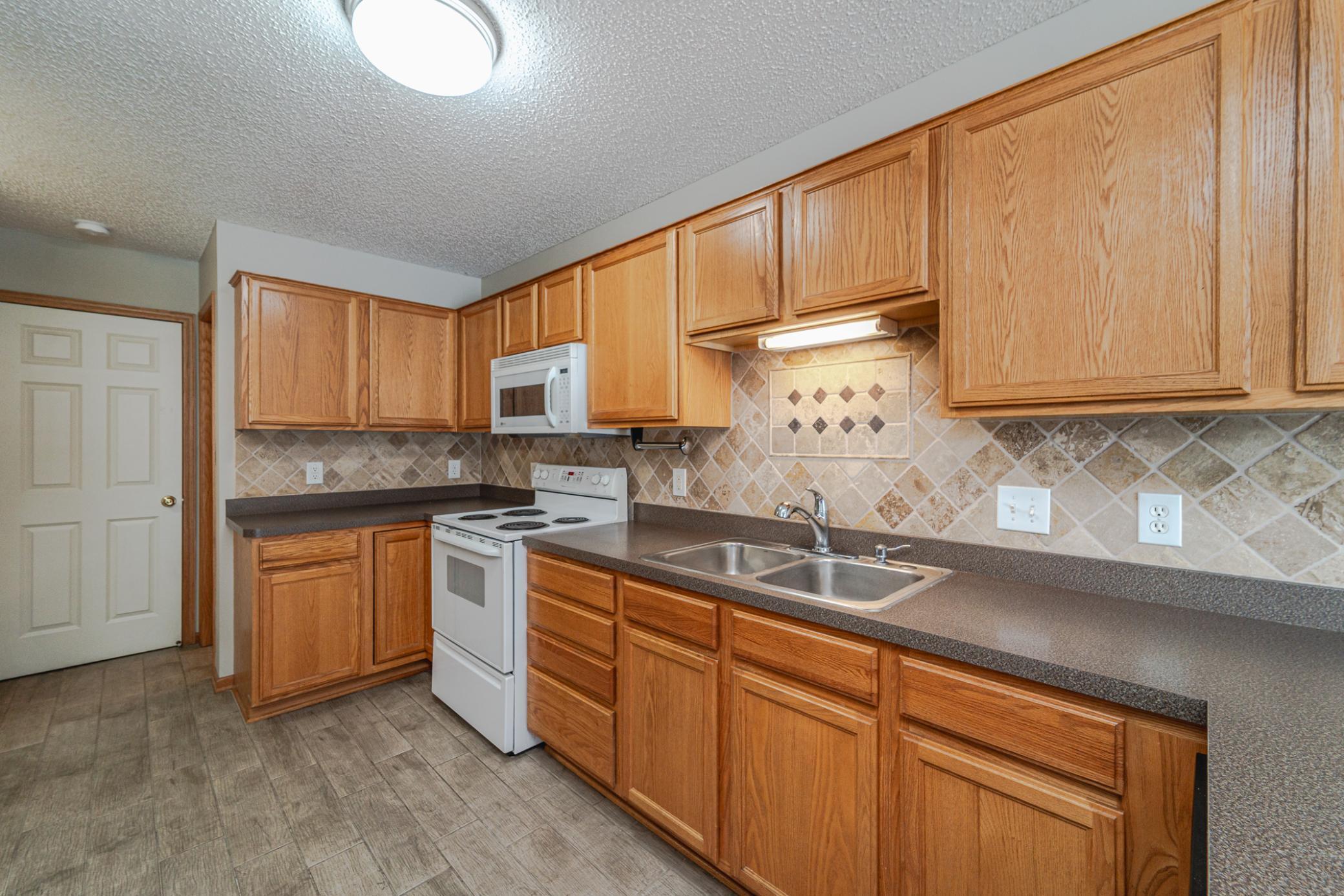 There's a tile backsplash and a light above the sink.