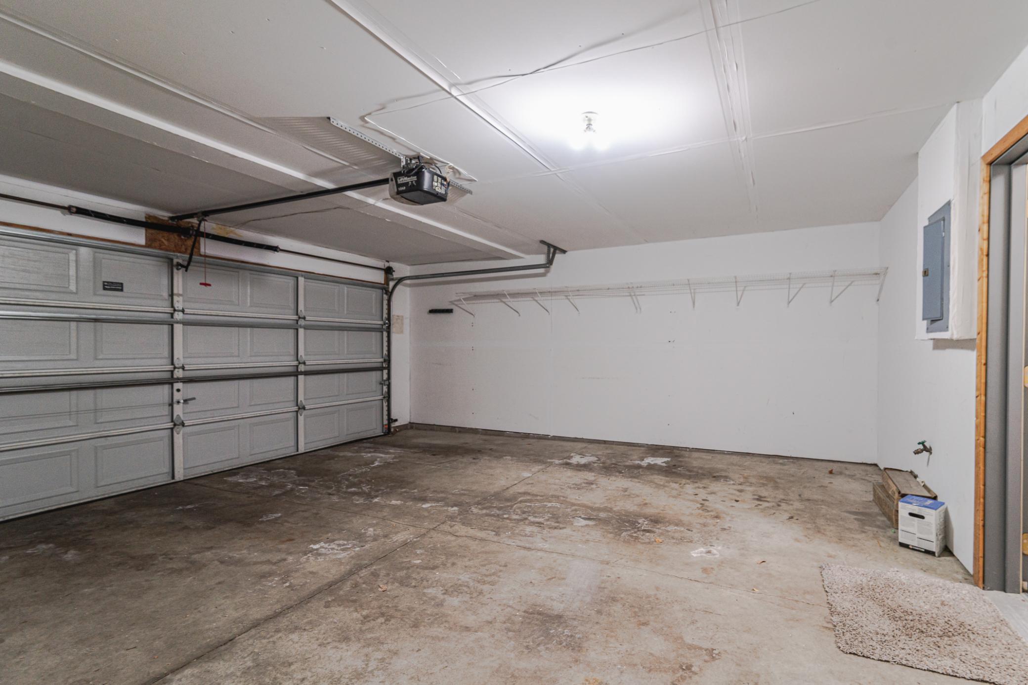 The two-car garage has shelving.