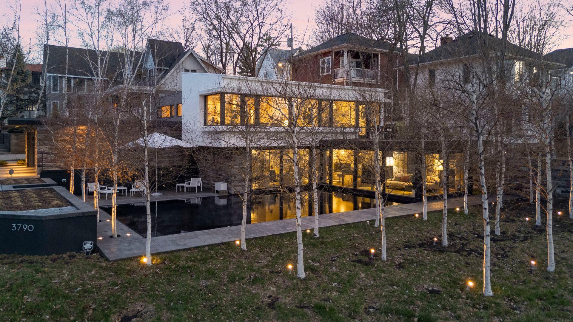 Reflecting pool and birch grove with landscape lighting sets a serene tone for the entire property.