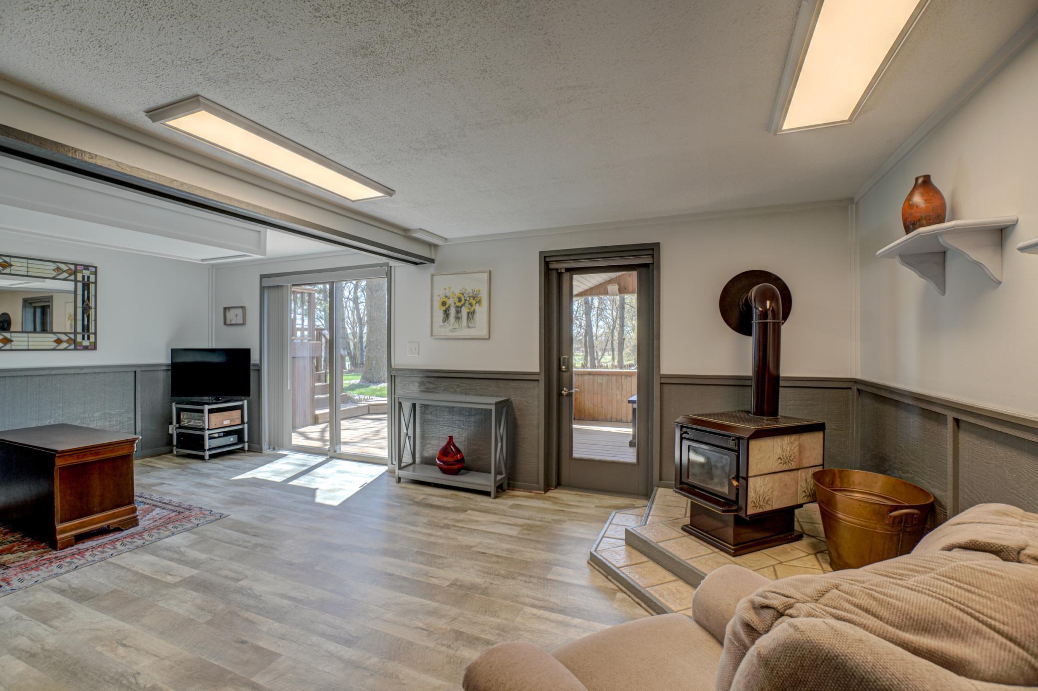 The finished walkout lower level expands the living space with new flooring, a cozy wood stove, and access to a lower-level deck, along with an additional covered porch.