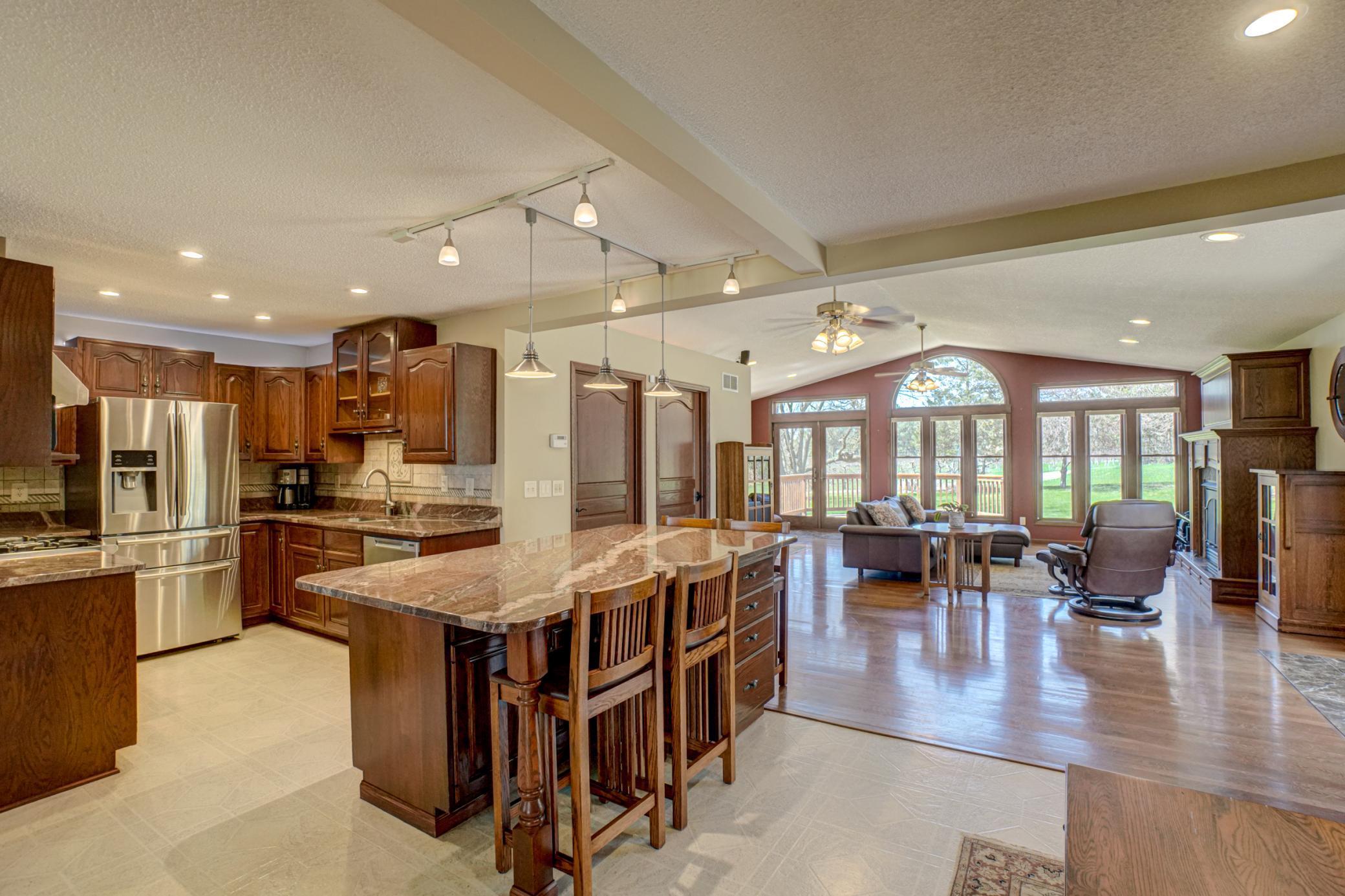 An expansive open-concept layout welcomes you in, highlighted by oak floors, a beautiful fireplace, and large windows that frame serene country views while filling the home with natural light.