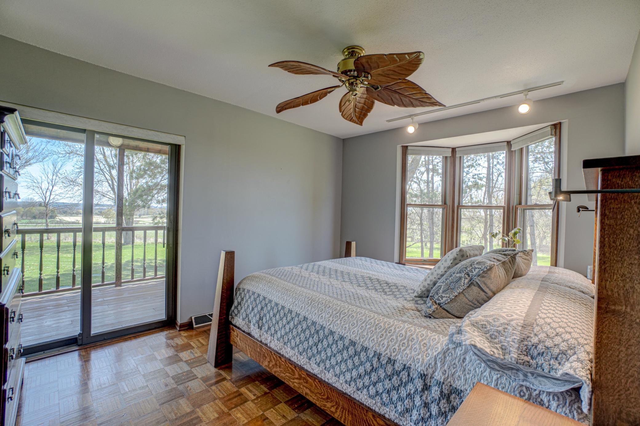 Primary bedroom with a bay window and direct access to the charming wraparound porch.