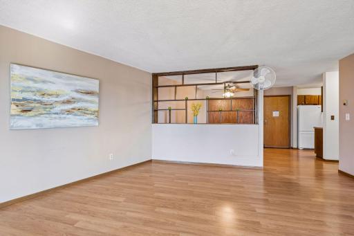 Living room with unique divider separation from dining room! This view faces the front door from the south wall of the unit.