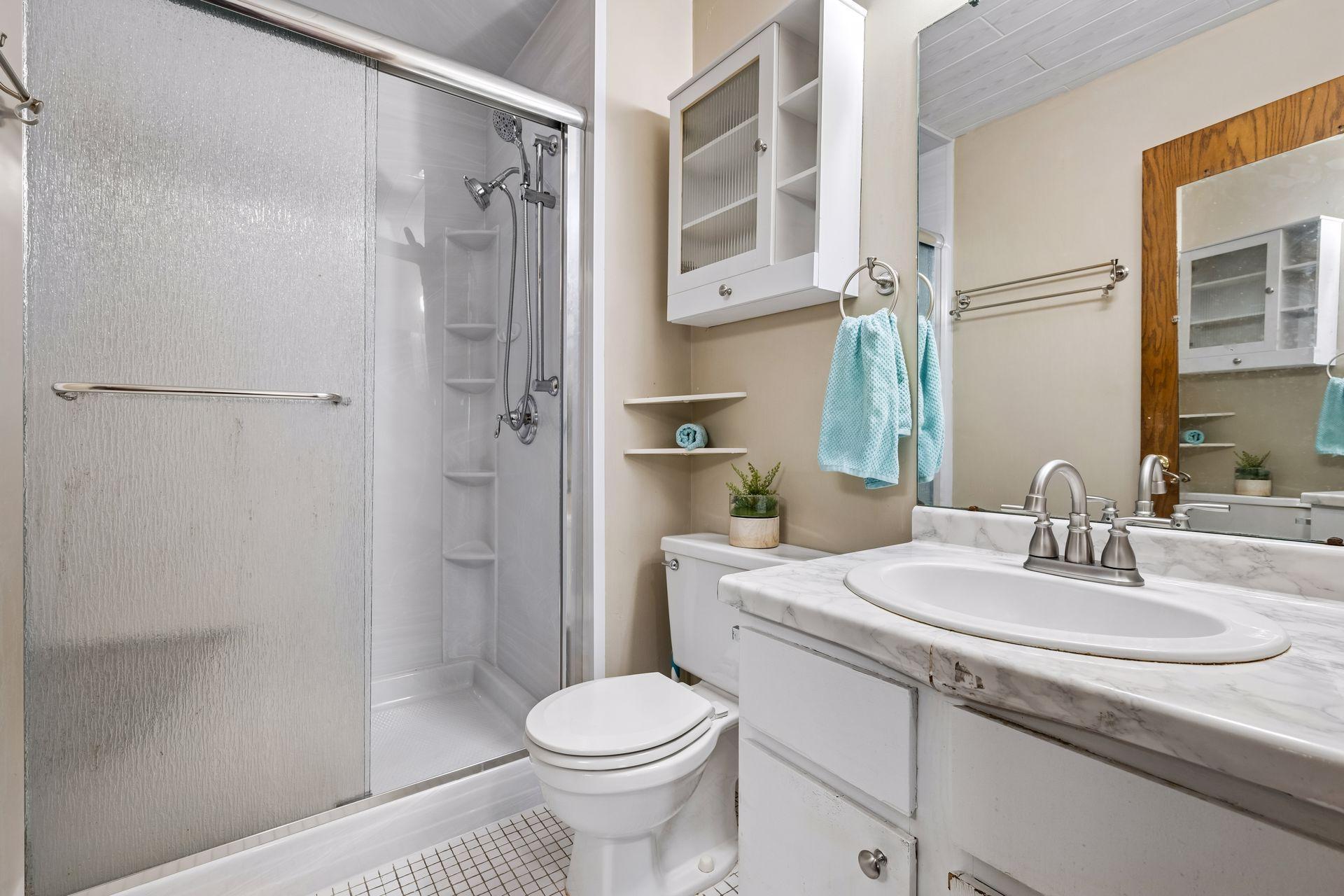Tiled floors and glass-enclosed shower in primary bathroom.
