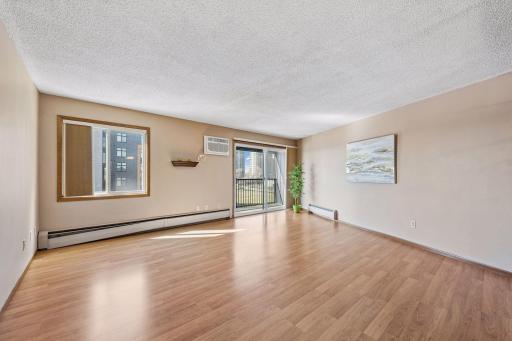 Large living room space with south facing windows and the patio door to the screened in balcony.