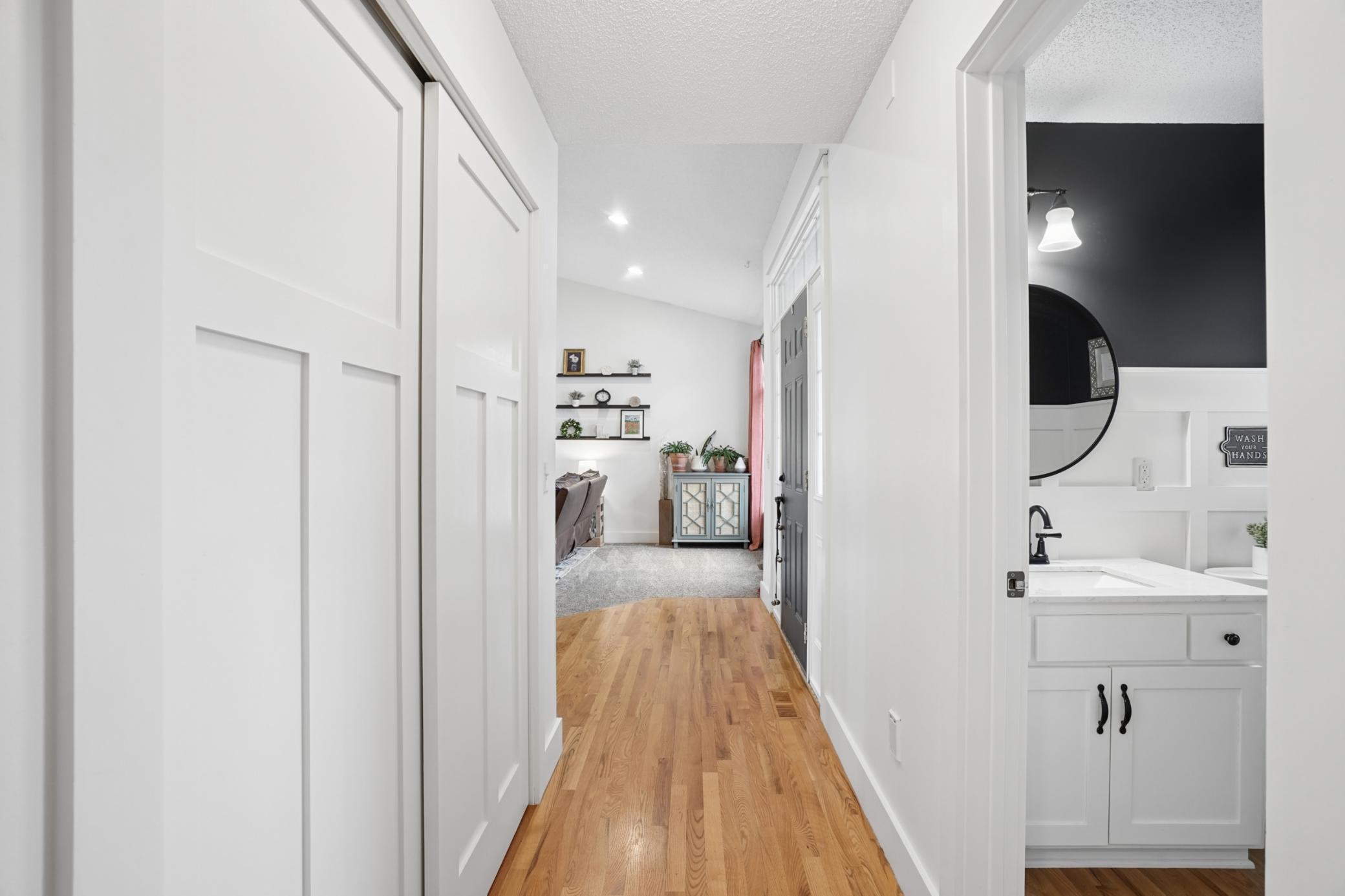 Main floor hall view showing real hardwood floors and large closet space