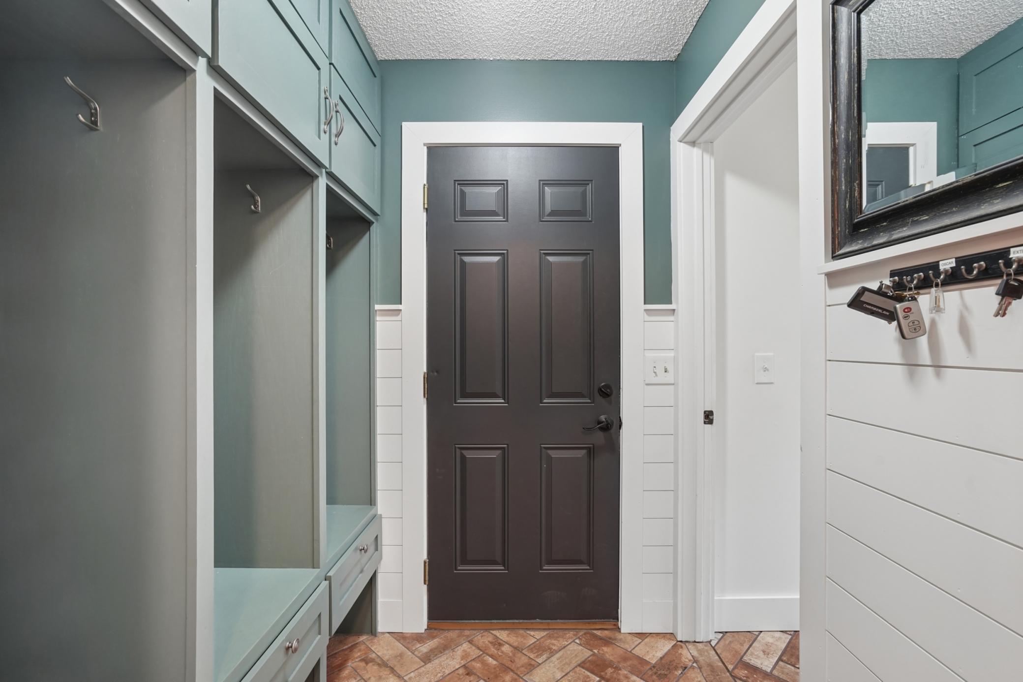Mud room off the garage is spacious and offers shiplap and built in locker system