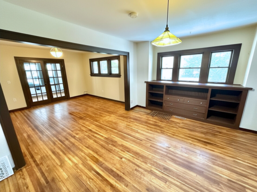 Sun-filled living space featuring beautiful hardwood floors and classic Craftsman-style details.