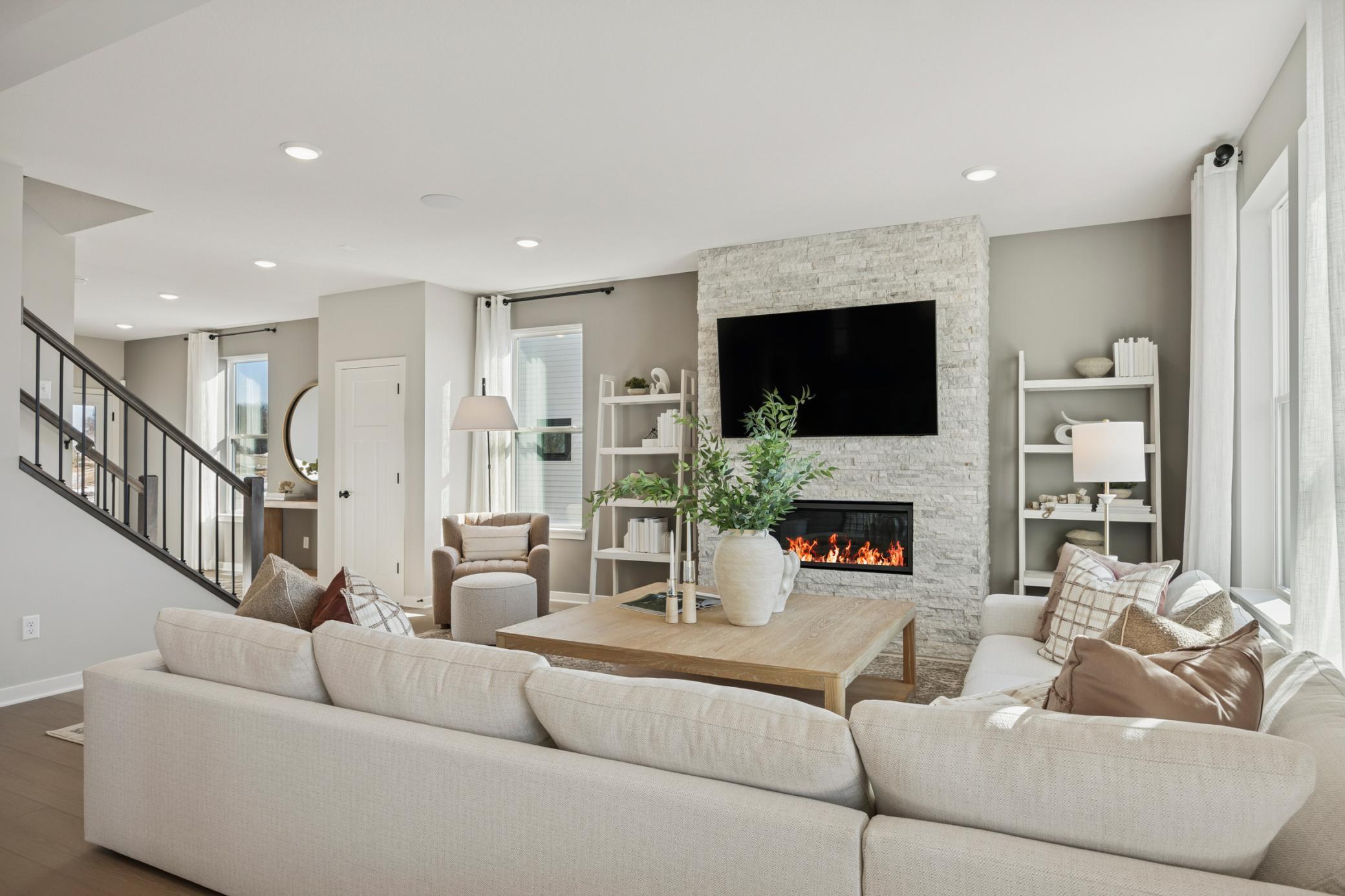Spacious family room at the heart of the home, featuring soaring 9-foot ceilings and a cozy fireplace that adds warmth and charm.