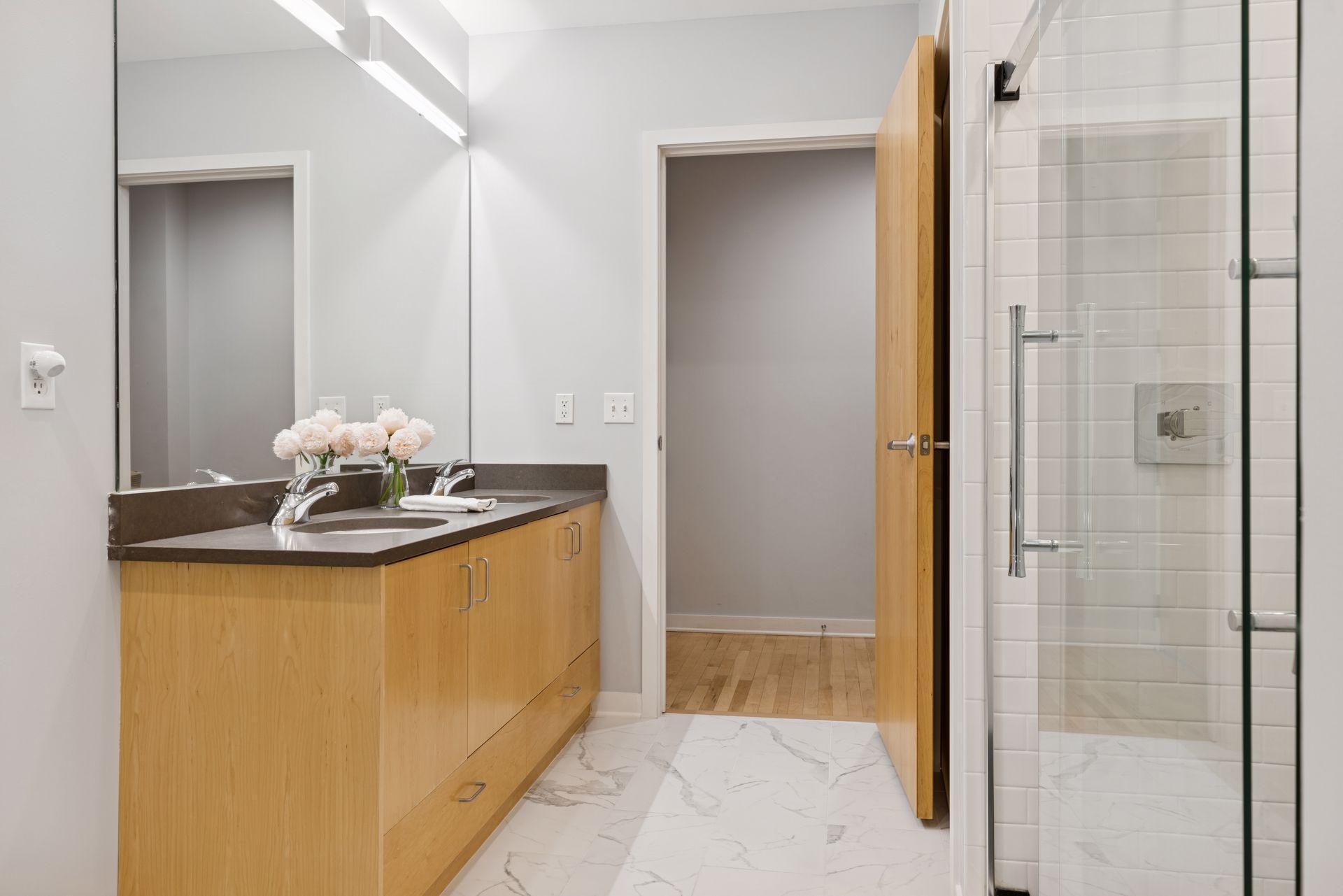 Completely renovated bathroom features a spa-like tile shower-for-two and double vanity