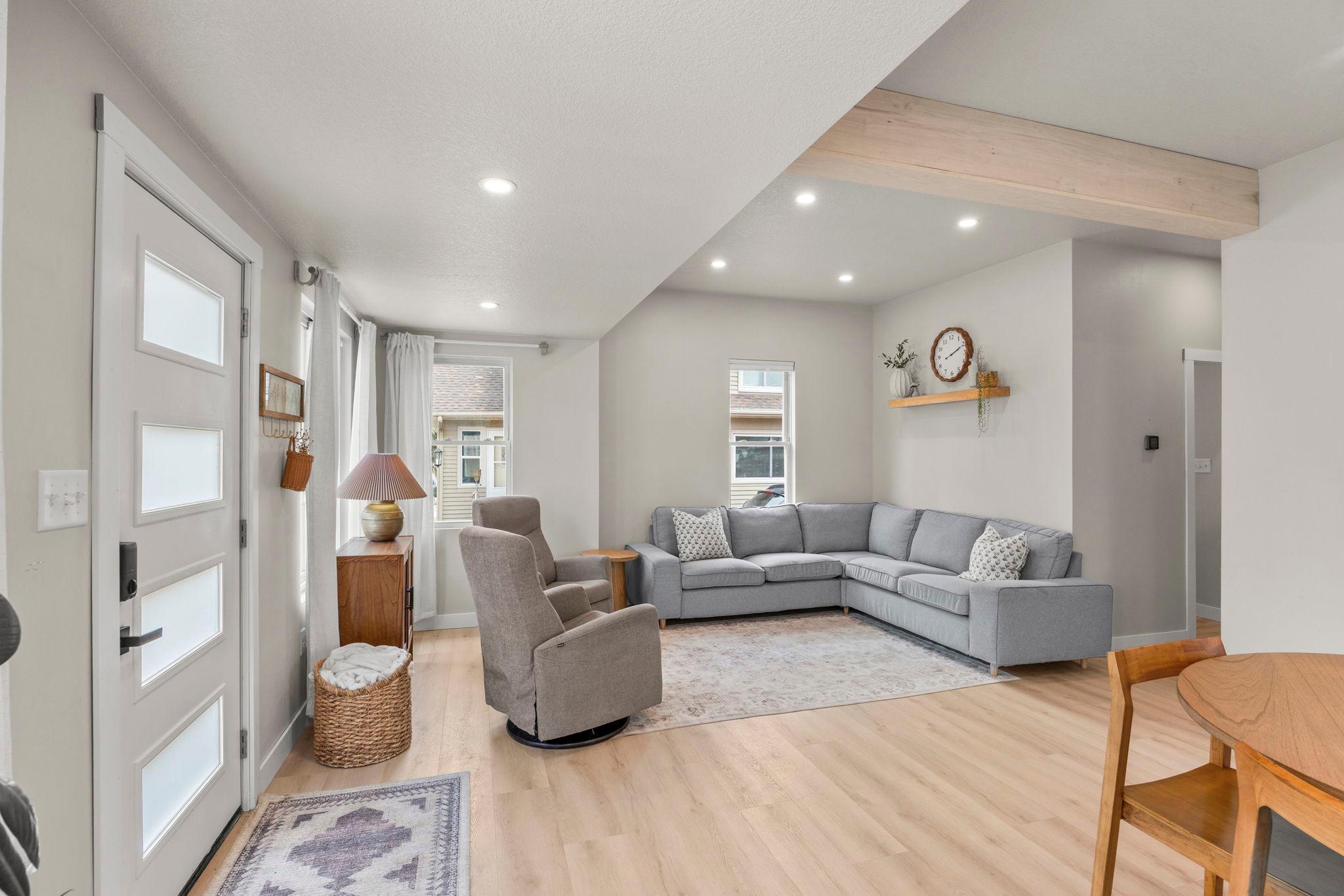 The living room complete with an exposed beam and recessed lighting—with abundant natural light.