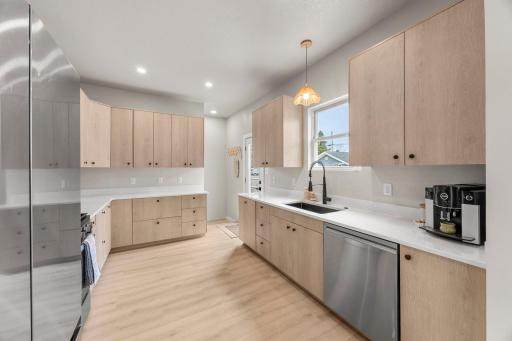The beautifully updated kitchen features quartz countertops, stainless steel appliances, and ample cabinetry.