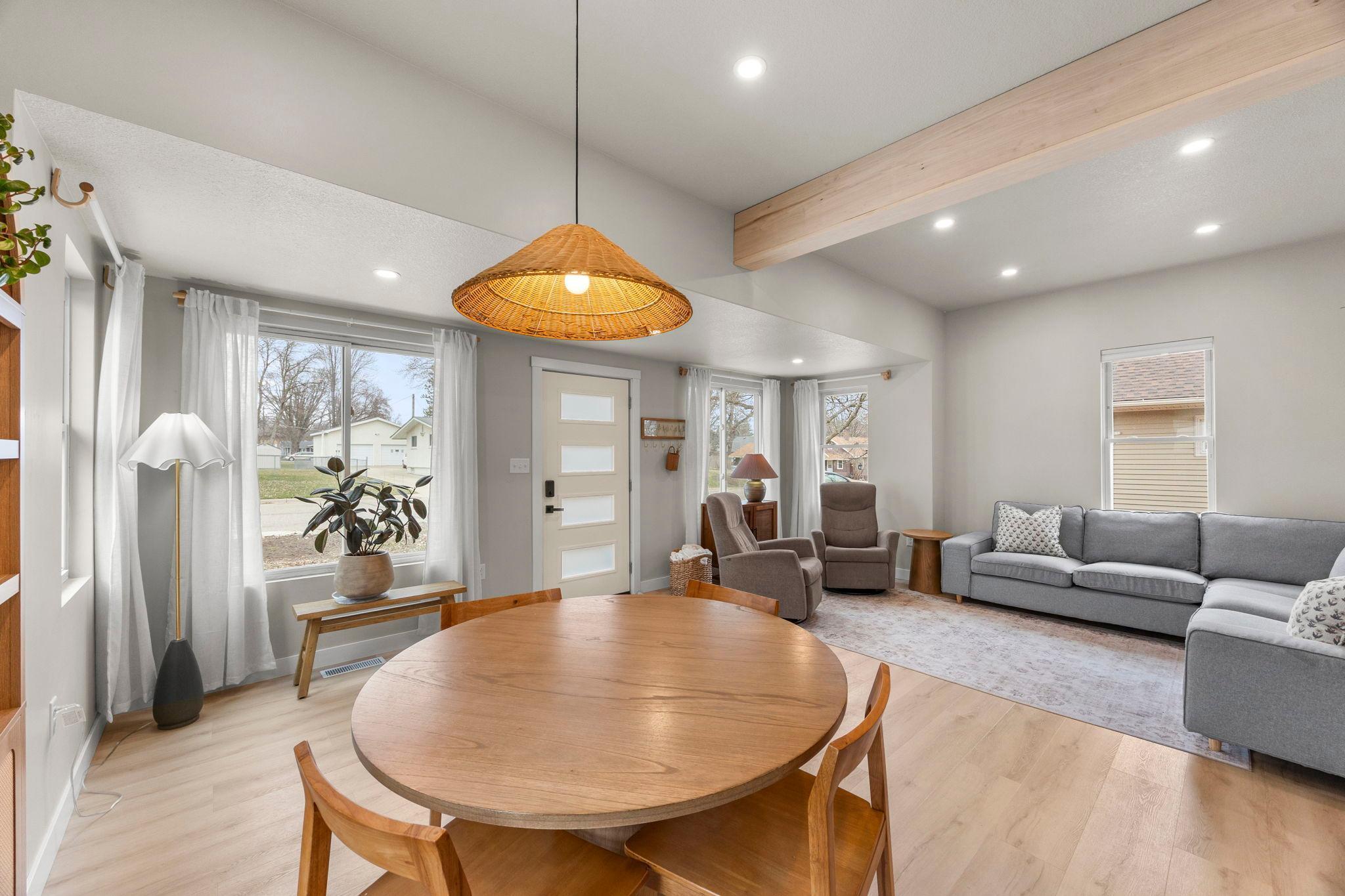 The dining space is highlighted by a modern statement light fixture and recessed lighting.