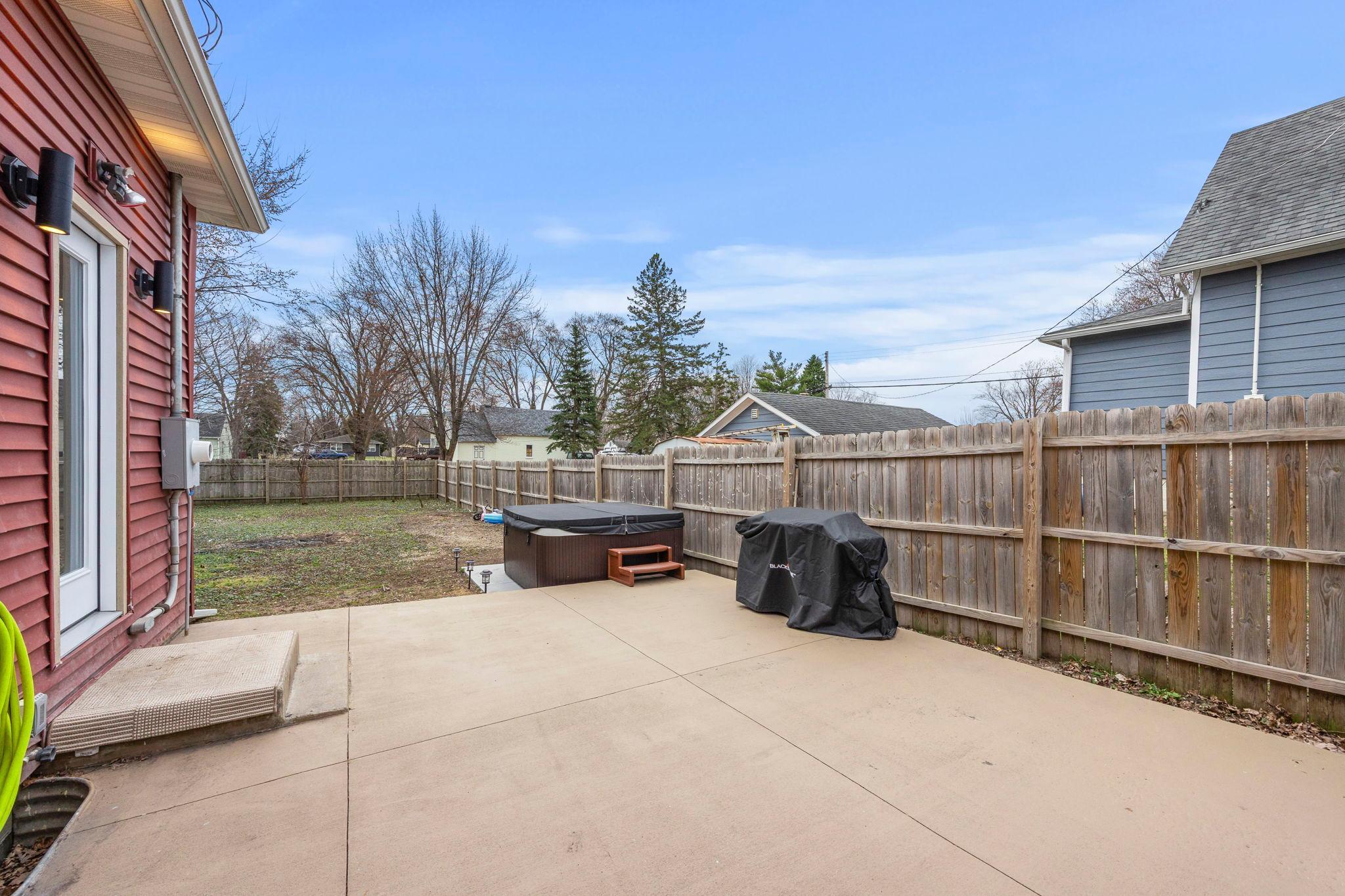 Another view of the patio and additional parking, overlooking the fenced yard.