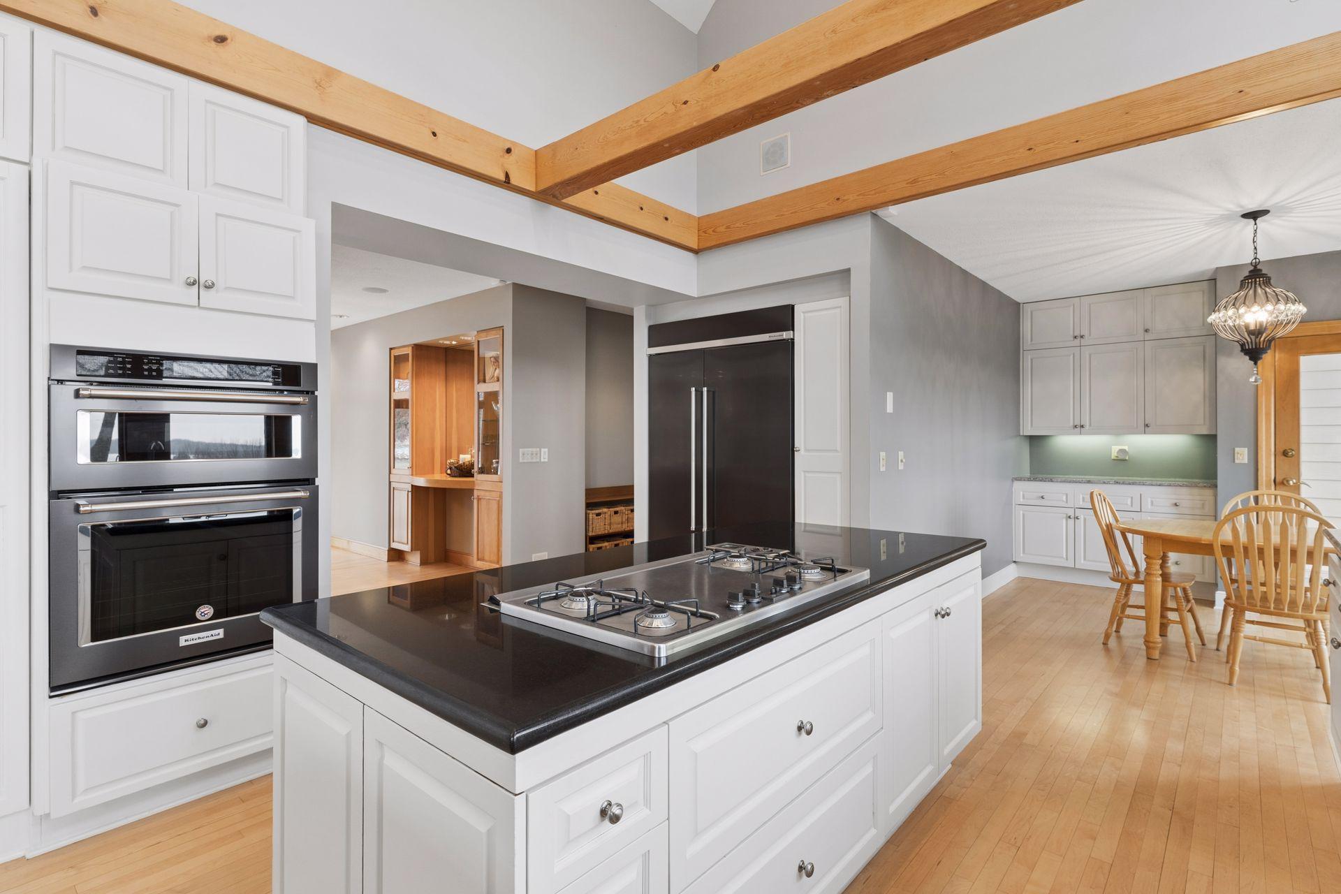 The space is equipped with KitchenAid appliances including a wall oven, warming drawer, built-in microwave and refrigerator.