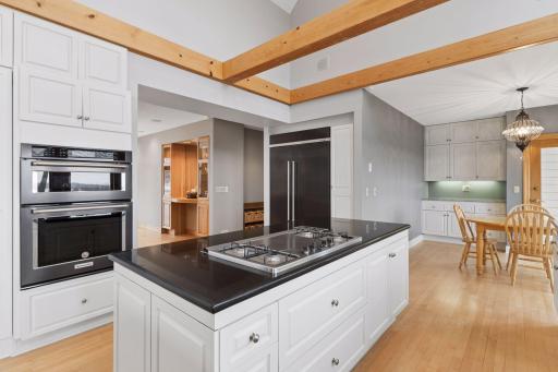 The space is equipped with KitchenAid appliances including a wall oven, warming drawer, built-in microwave and refrigerator.