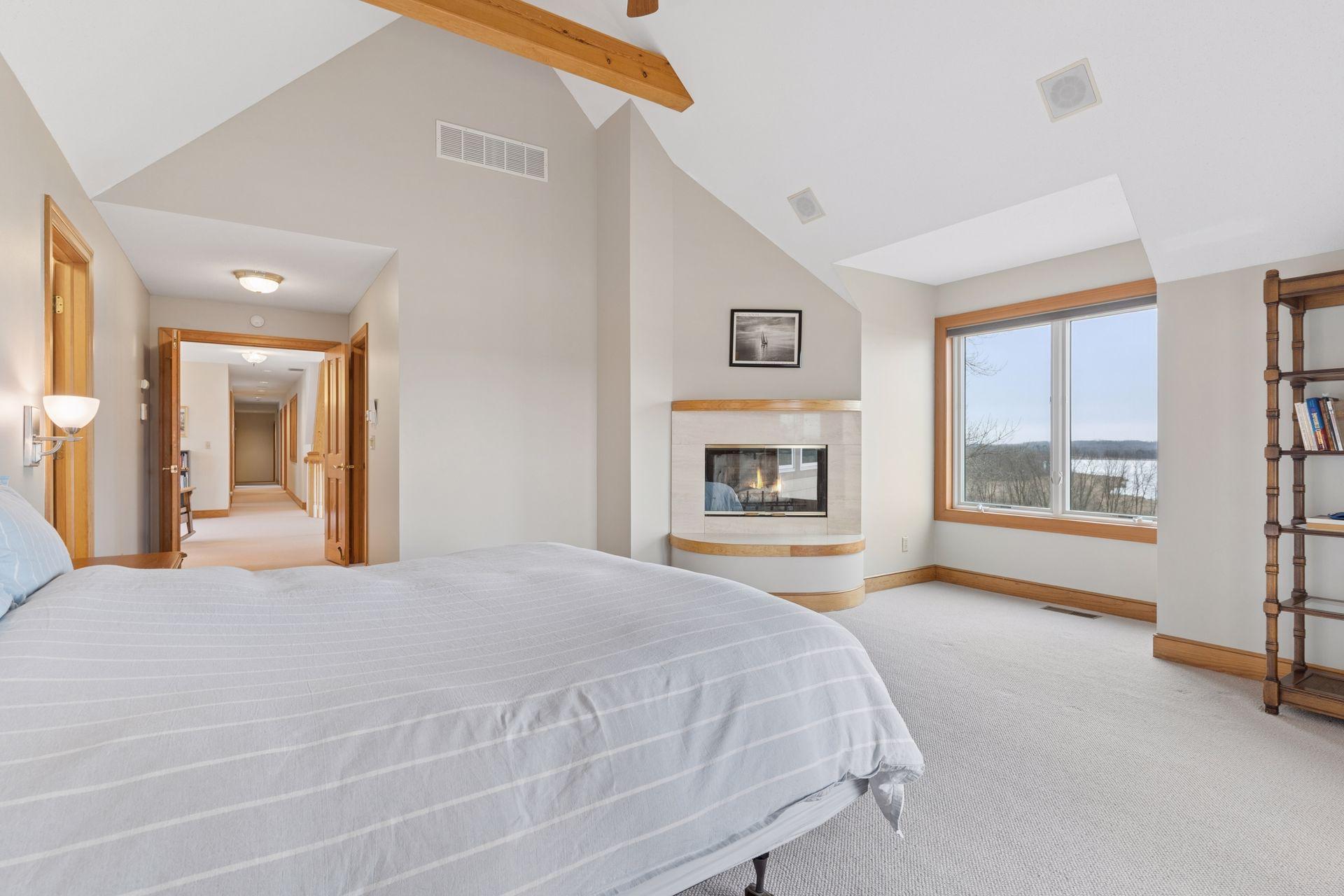 The Primary Suite is a private oasis with an inviting wood burning fireplace and uninterrupted views across the lake.