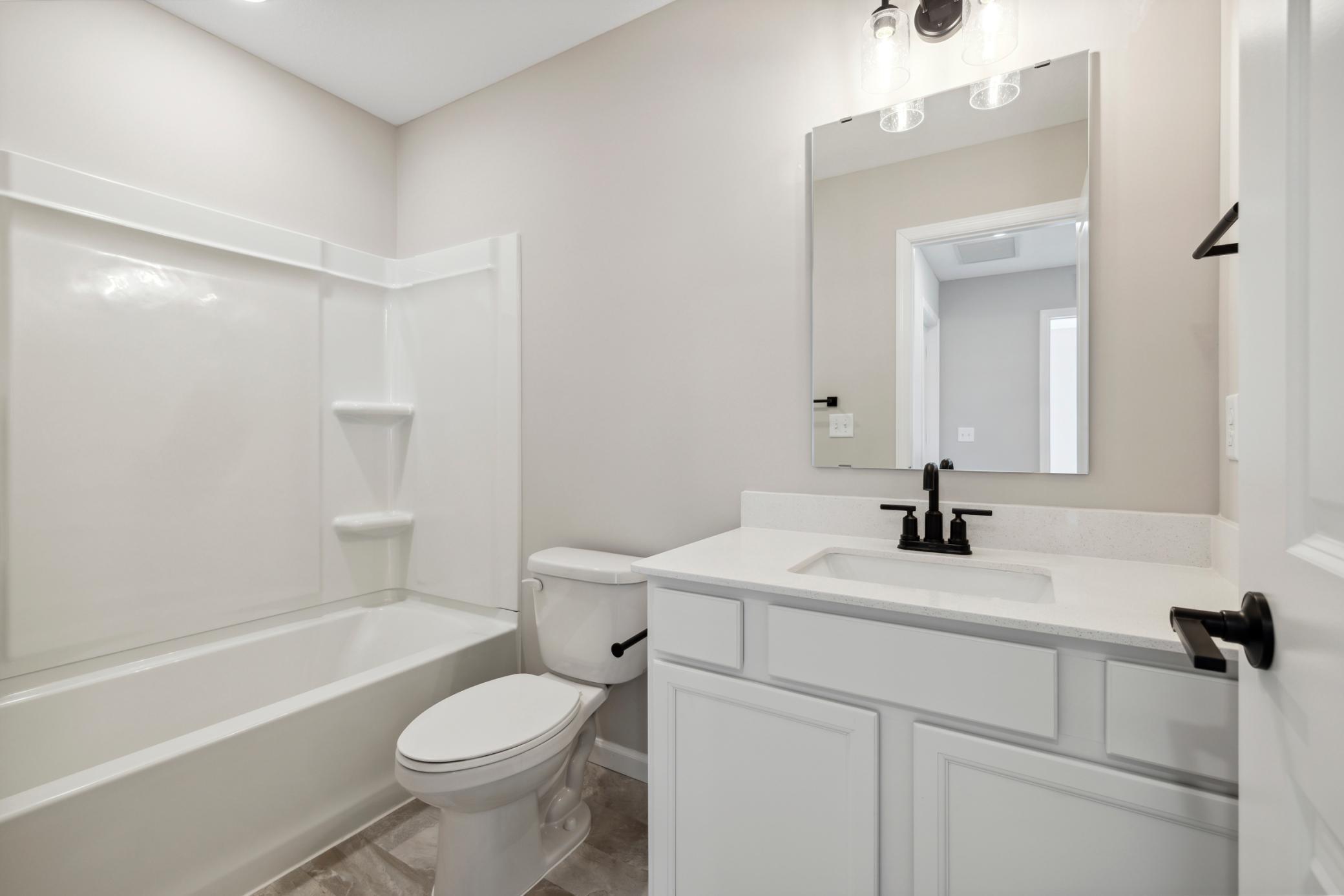 Thoughtful lighting and large mirror enhance the space, perfect for everyday routines