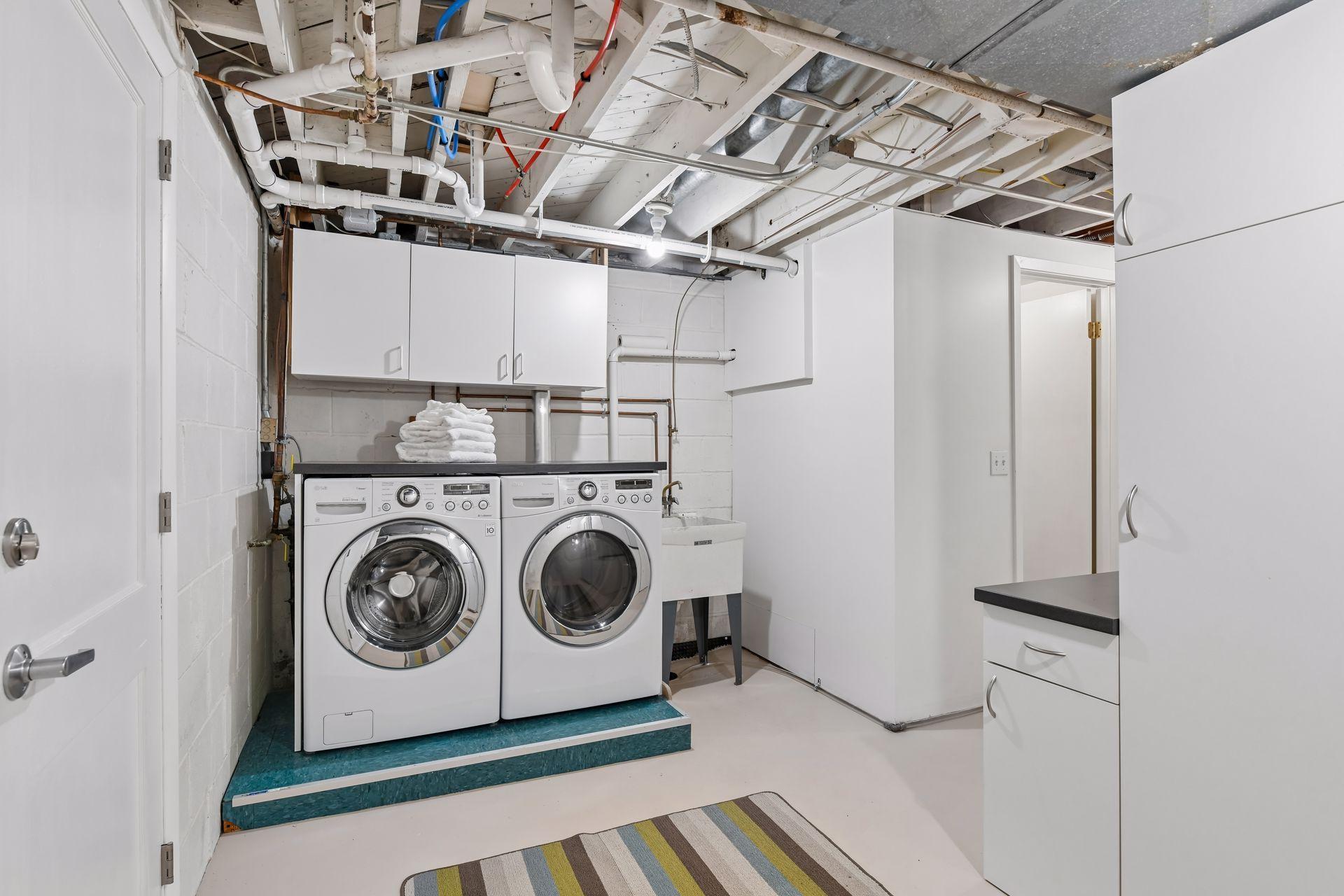 The large laundry/mud room has newer front load washer and dryer, built-in cabinetry, handy washtub and a second refrigerator.