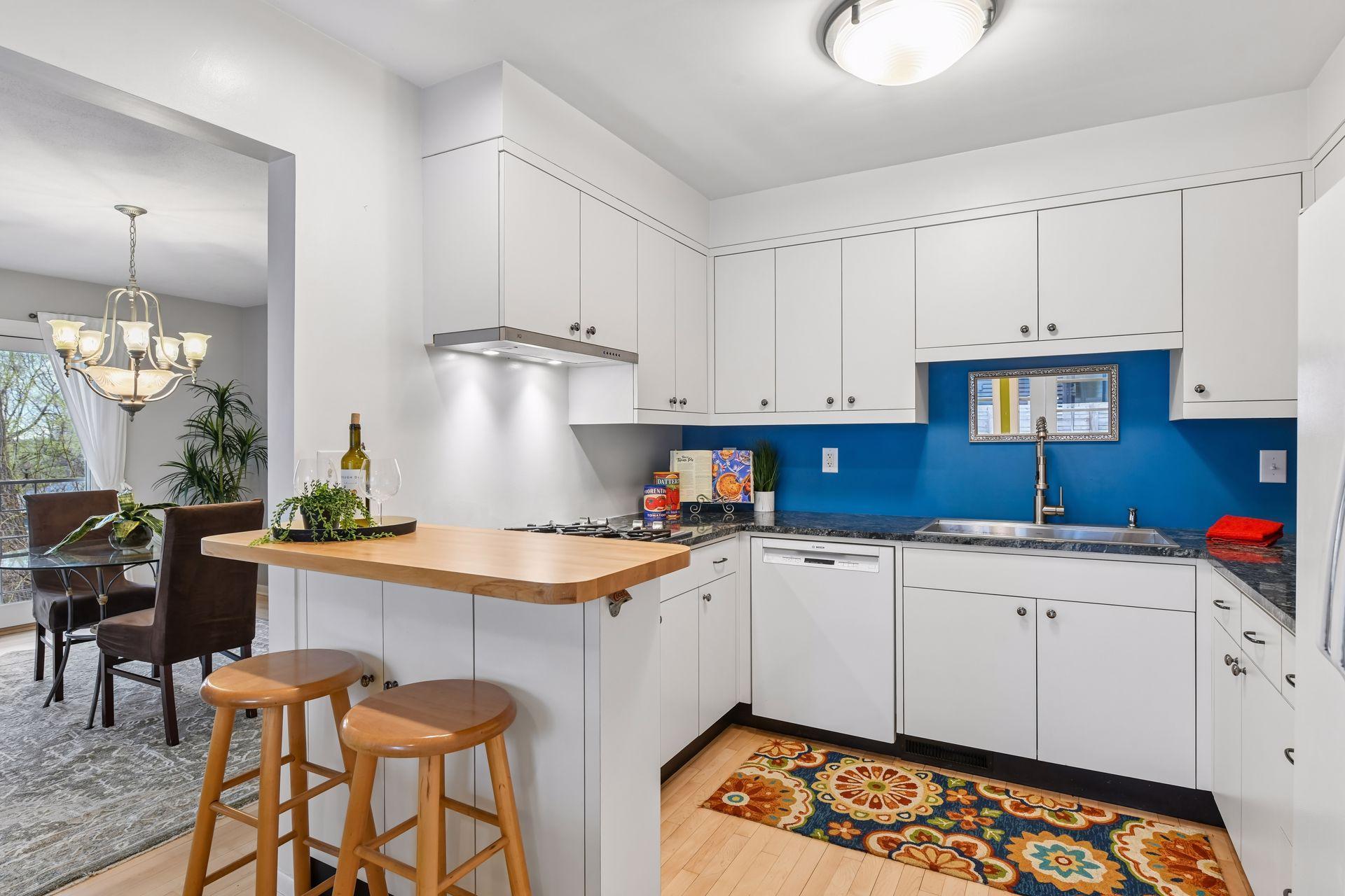 The efficiently designed kitchen has updated Melamine cabinetry, granite countertops and a handy butcher block breakfast bar.