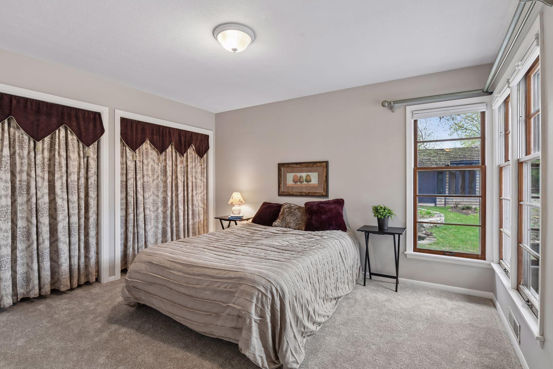 The main bedroom has two closets, newer plush carpeting and large corner windows overlooking the beautiful fully fenced yard and gardens.