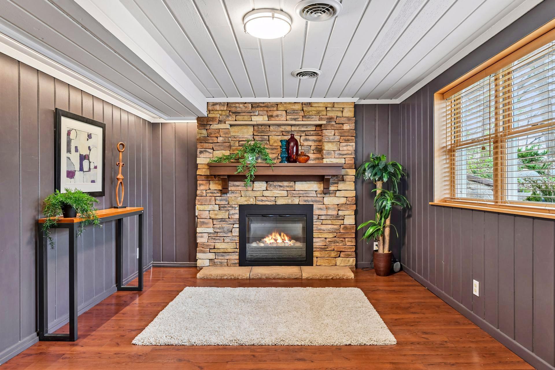 The walkout level famly room has a cozy gas fireplace with gorgeous stone facade, solid surface flooring and in floor heat.