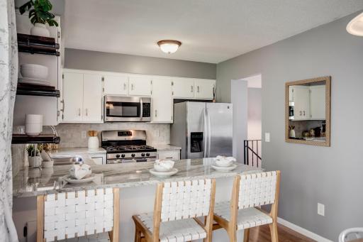 The recently updated kitchen features tile backsplash, granite countertops and stainless-steel appliances