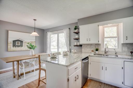 The dining area overlooks the backyard and includes a breakfast bar with seating
