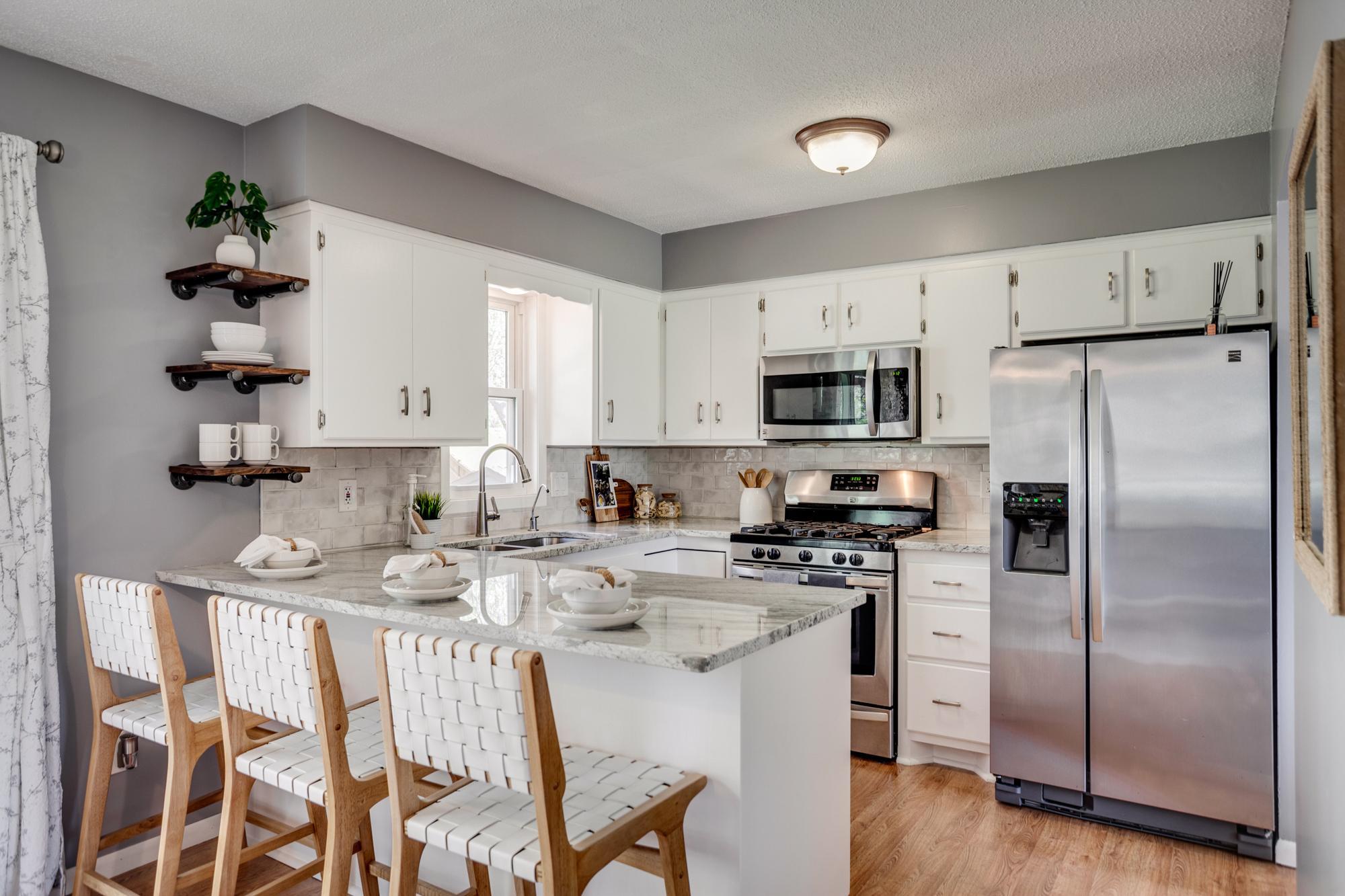 The recently updated kitchen features tile backsplash, granite countertops and stainless-steel appliances