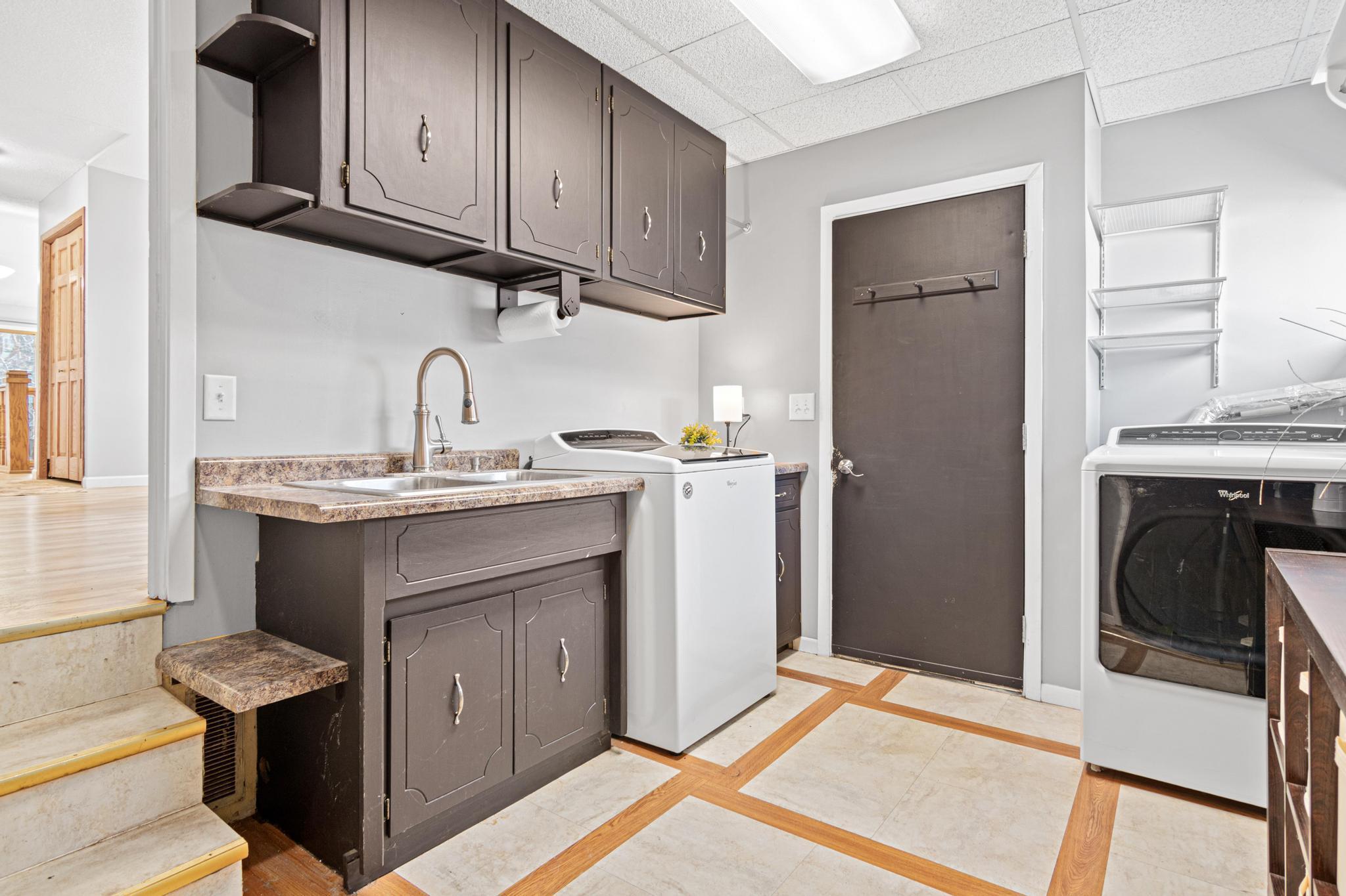 Functional laundry and utility space offering everyday convenience. Large storage room beyond the door.
