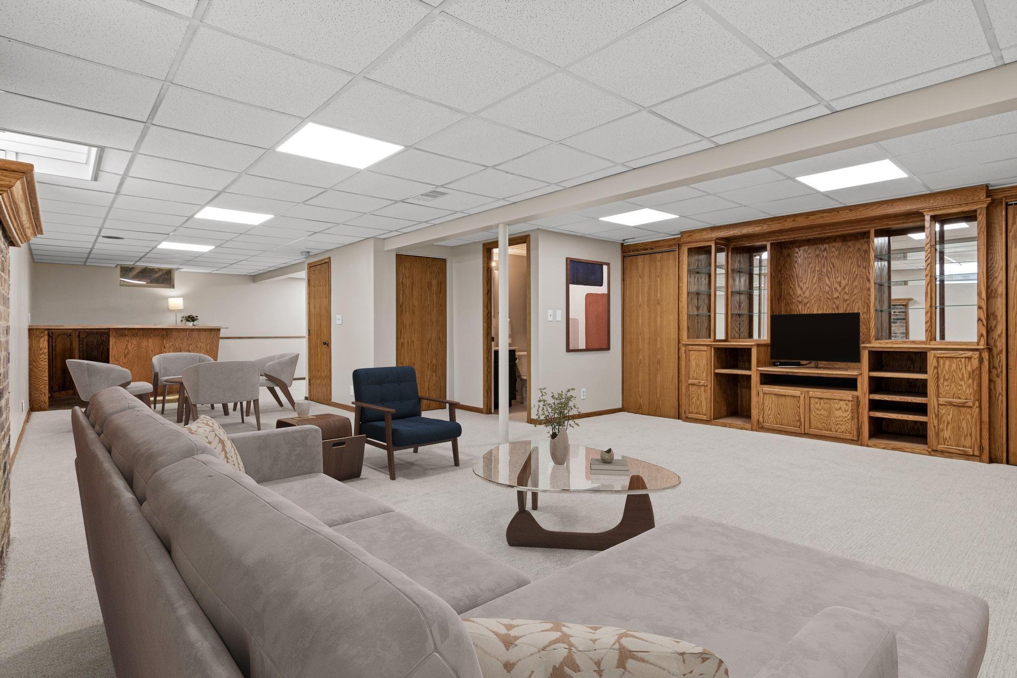 Cozy lower-level family room with new carpet (2026)—perfect for relaxing or movie nights. Visually staged.