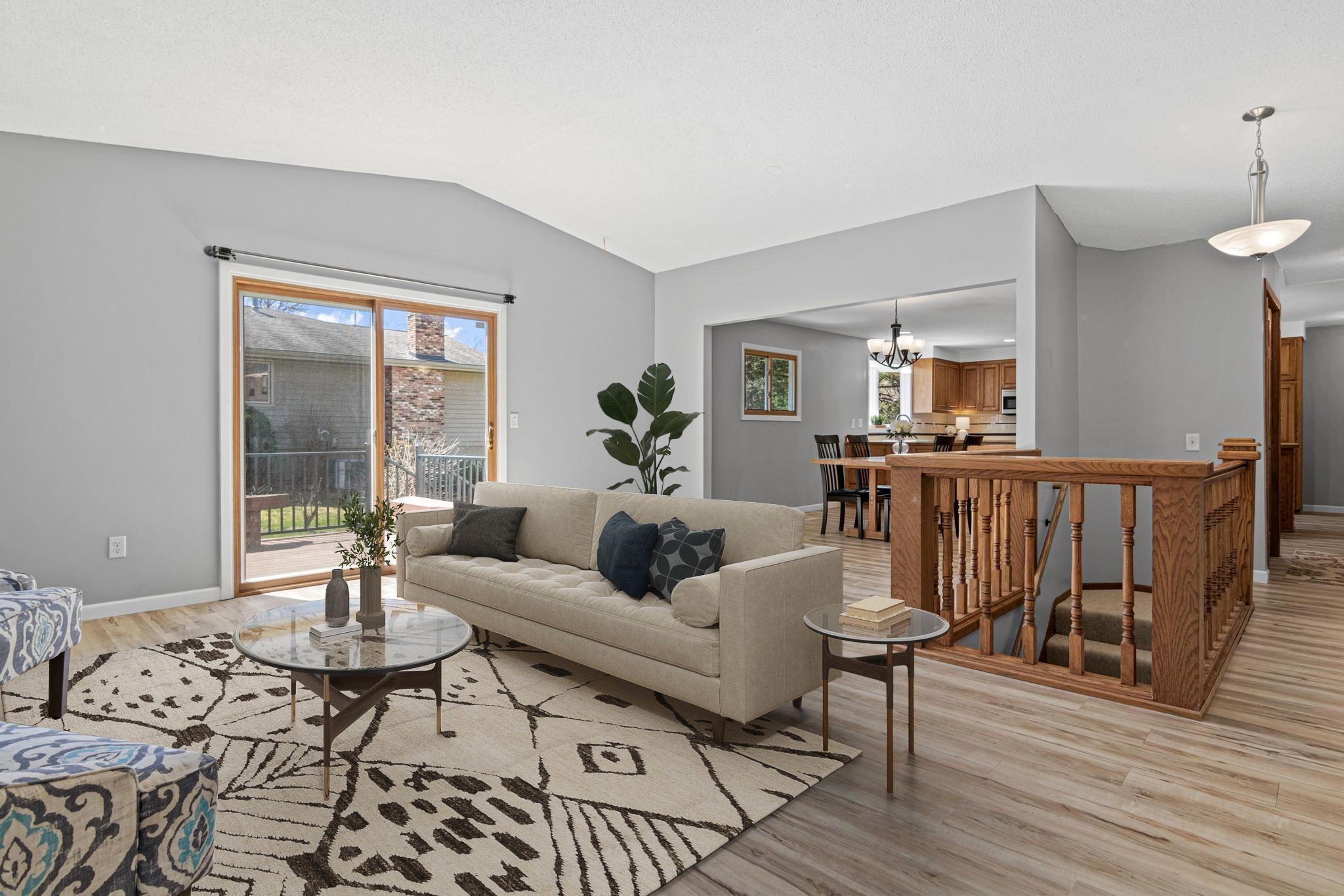 Light filled living room overlooks the beautiful backyard and new maintenance free deck. Visually staged.