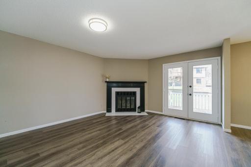 Wood burning fireplace w/ tile surround and black enameled mantle. French doors open to deck w/ private treeline.