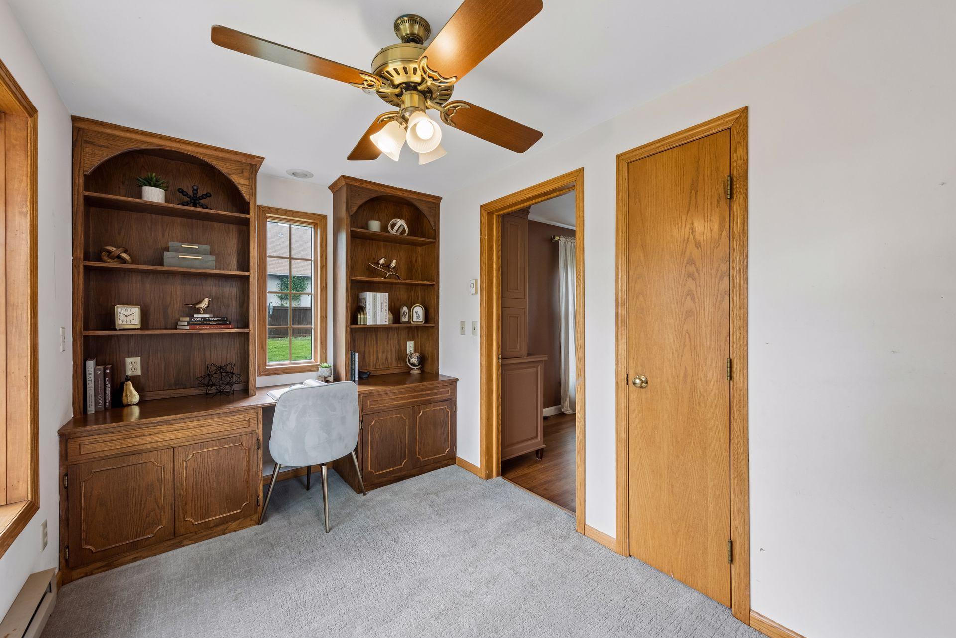 A dedicated office/den sits just off the living area, complete with built-ins that add both character and practical storage/workspace.