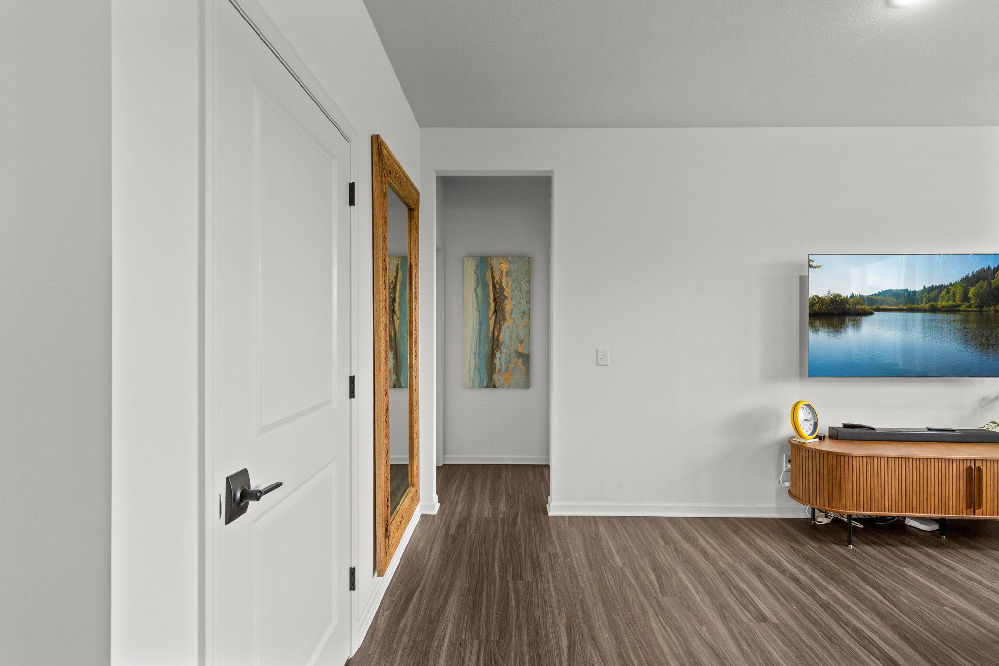 Off the living room is the hallway to bedrooms, including the primary suite