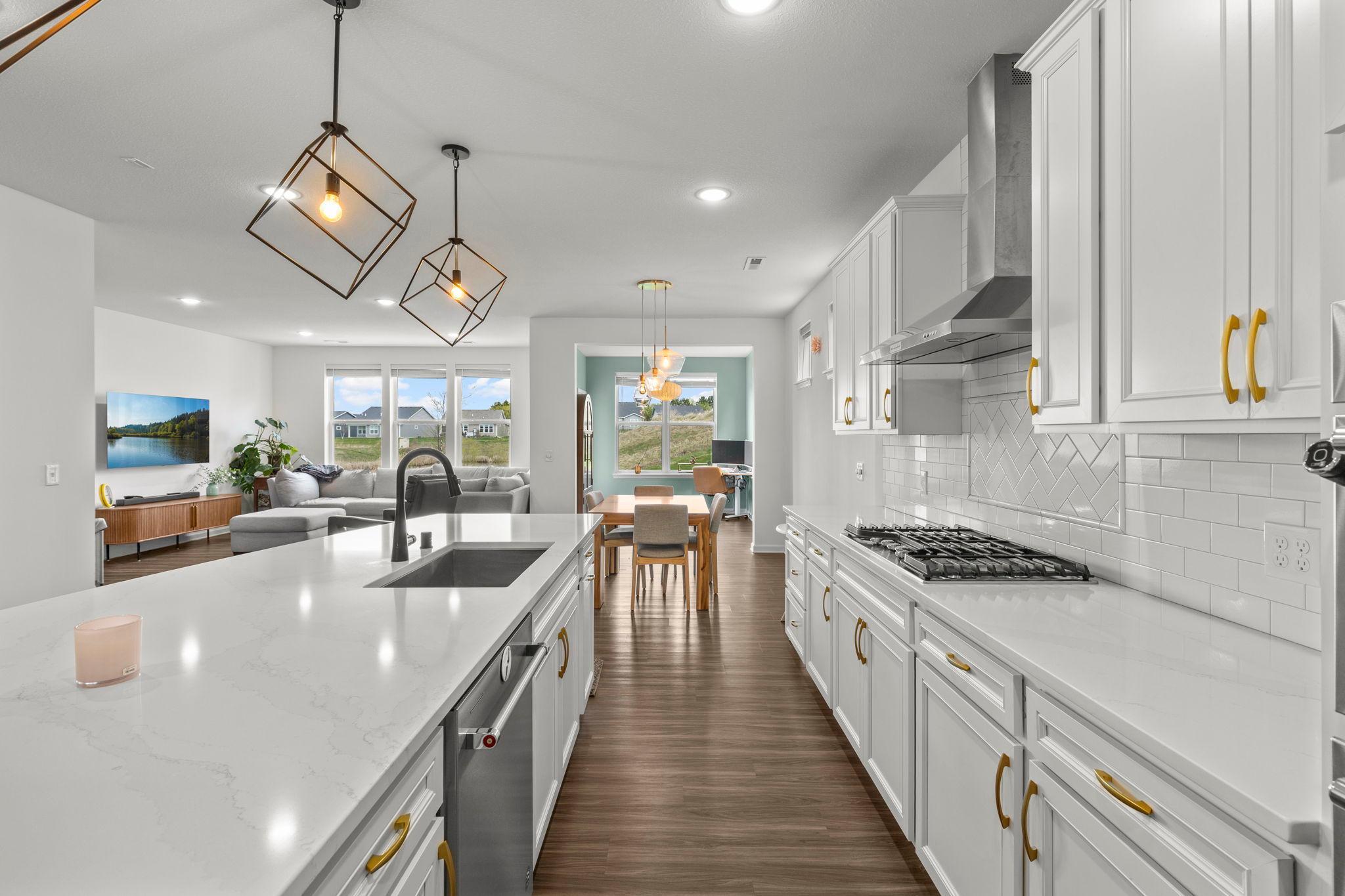 Stylish finishes shine with modern light fixtures, upgraded hardware, stainless steel appliances, and sleek granite countertops paired with a tile backsplash