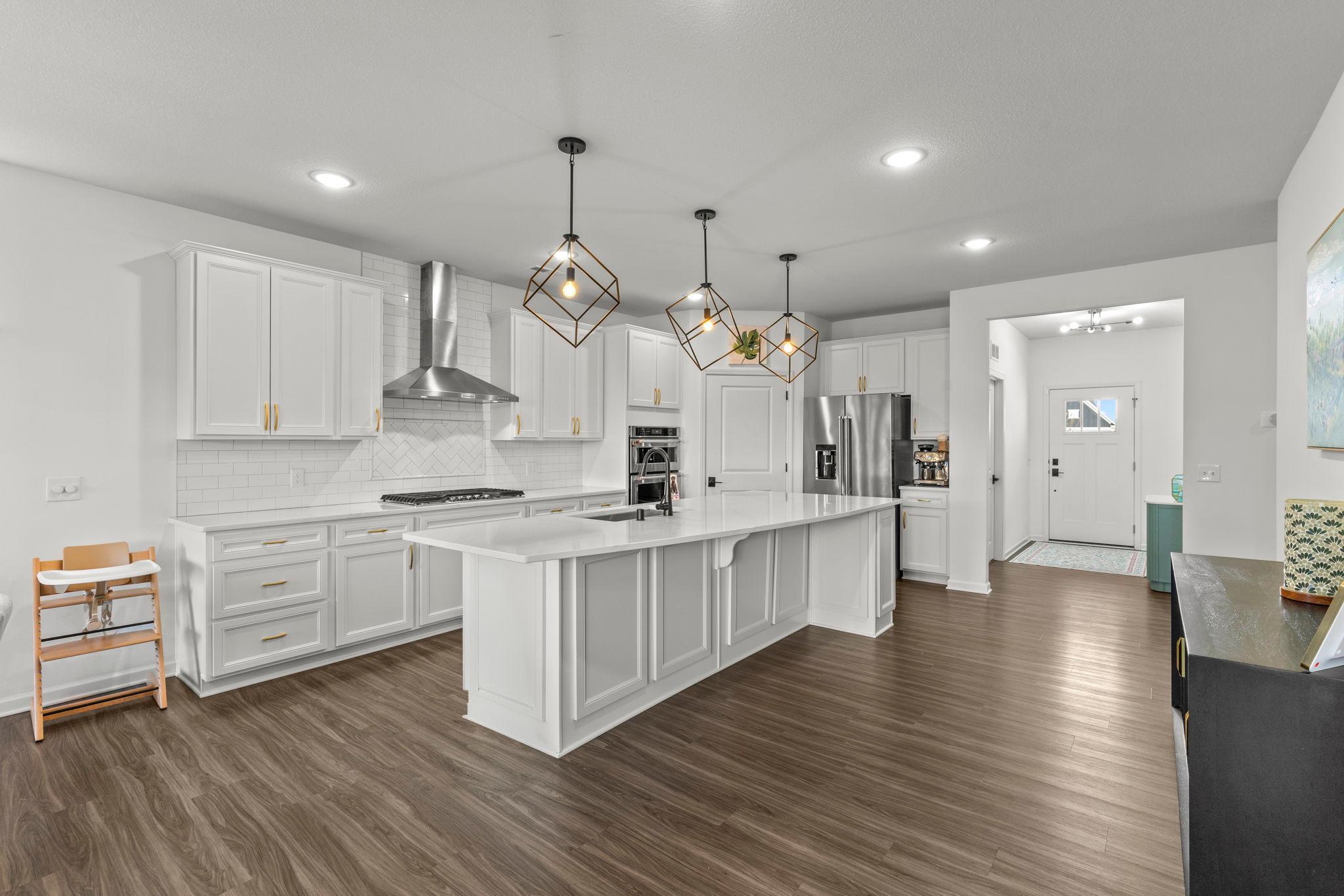 Open-concept, single-level living shines with a spacious white kitchen and oversized island perfect for gathering