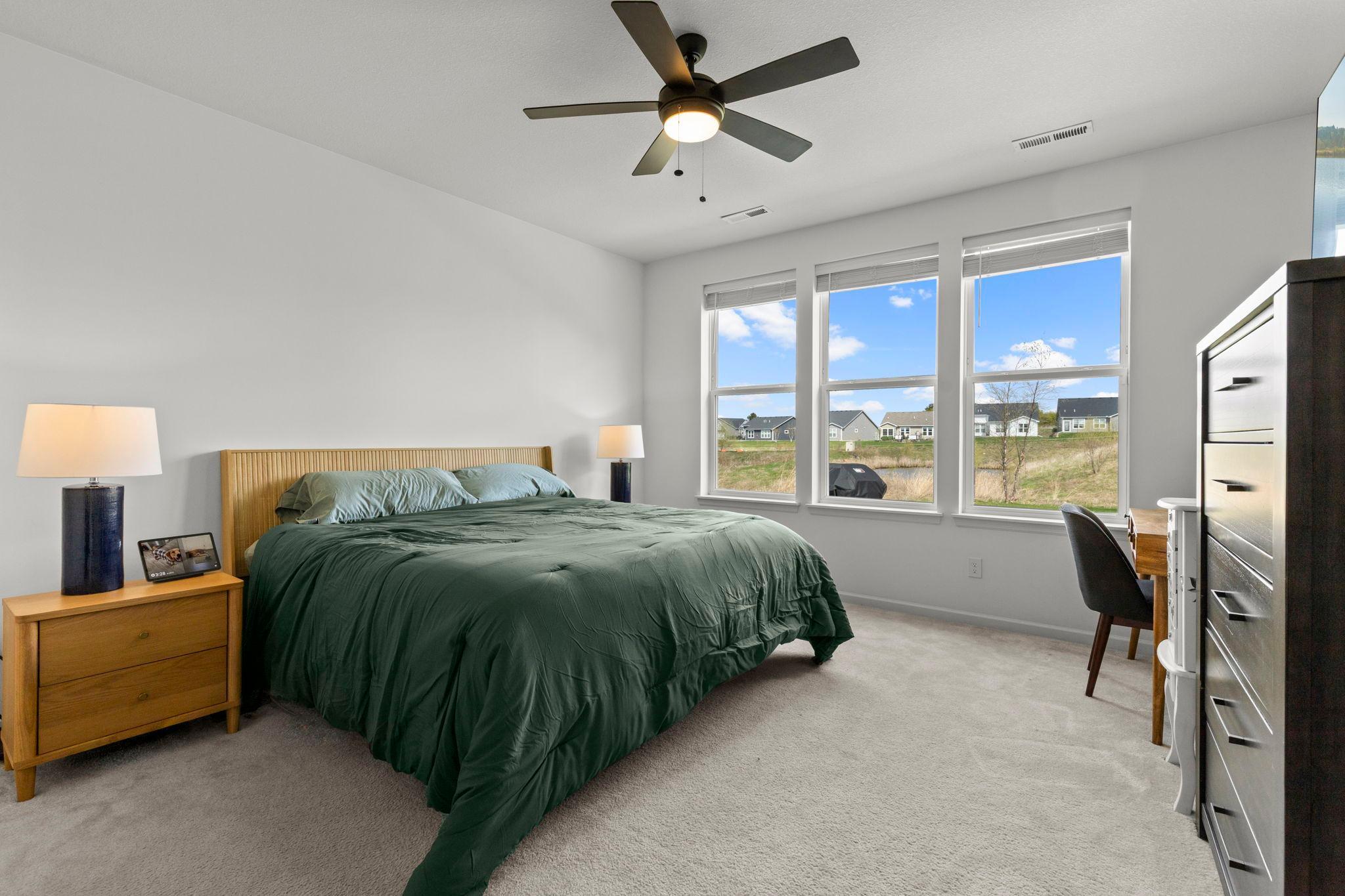 The primary bedroom features beautiful yard views through large picture windows