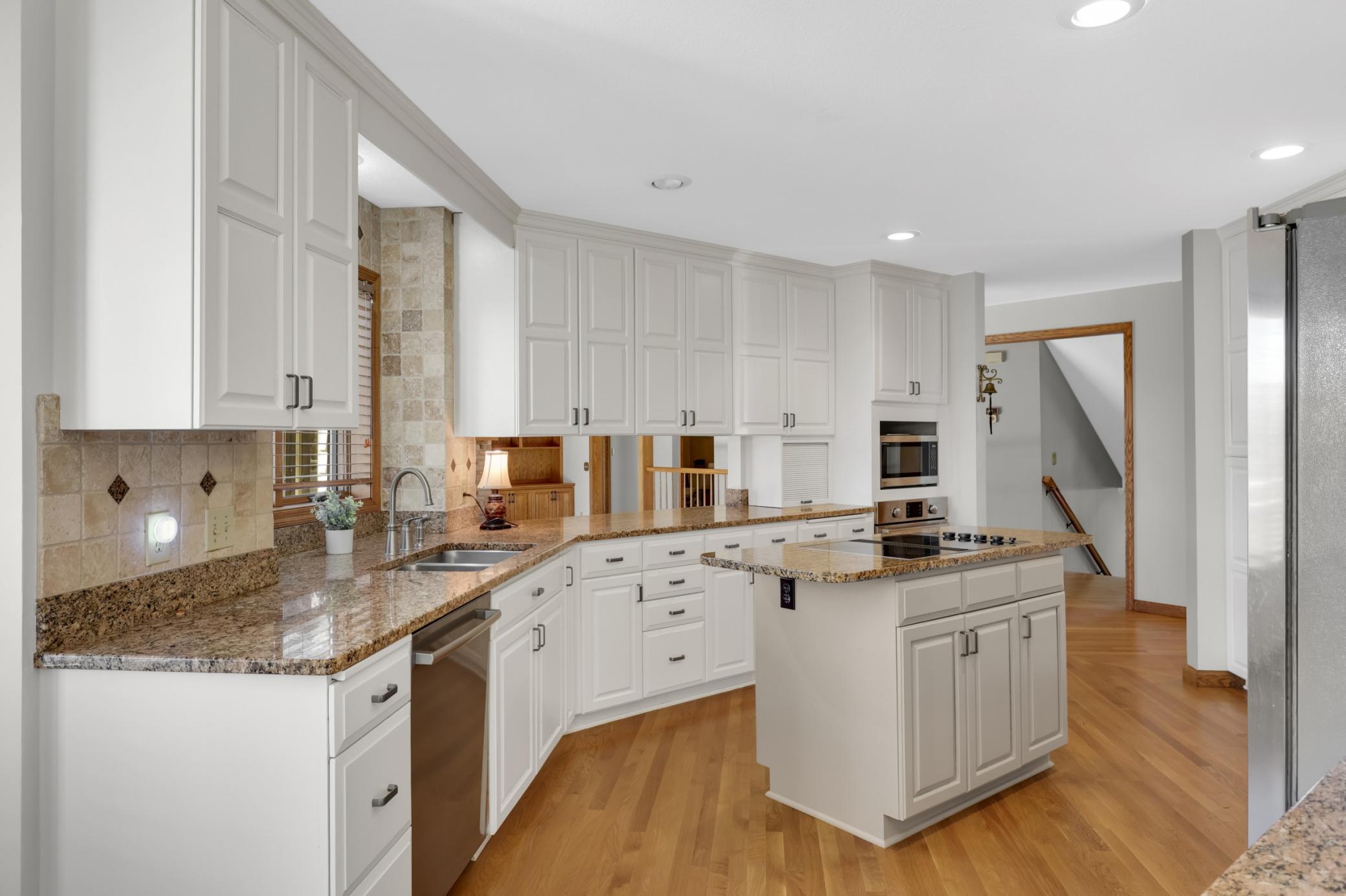 Gorgeous kitchen with an abundance of cabinet and counter space. Center island cooktop with back draft venting. So much storage in this kitchen!