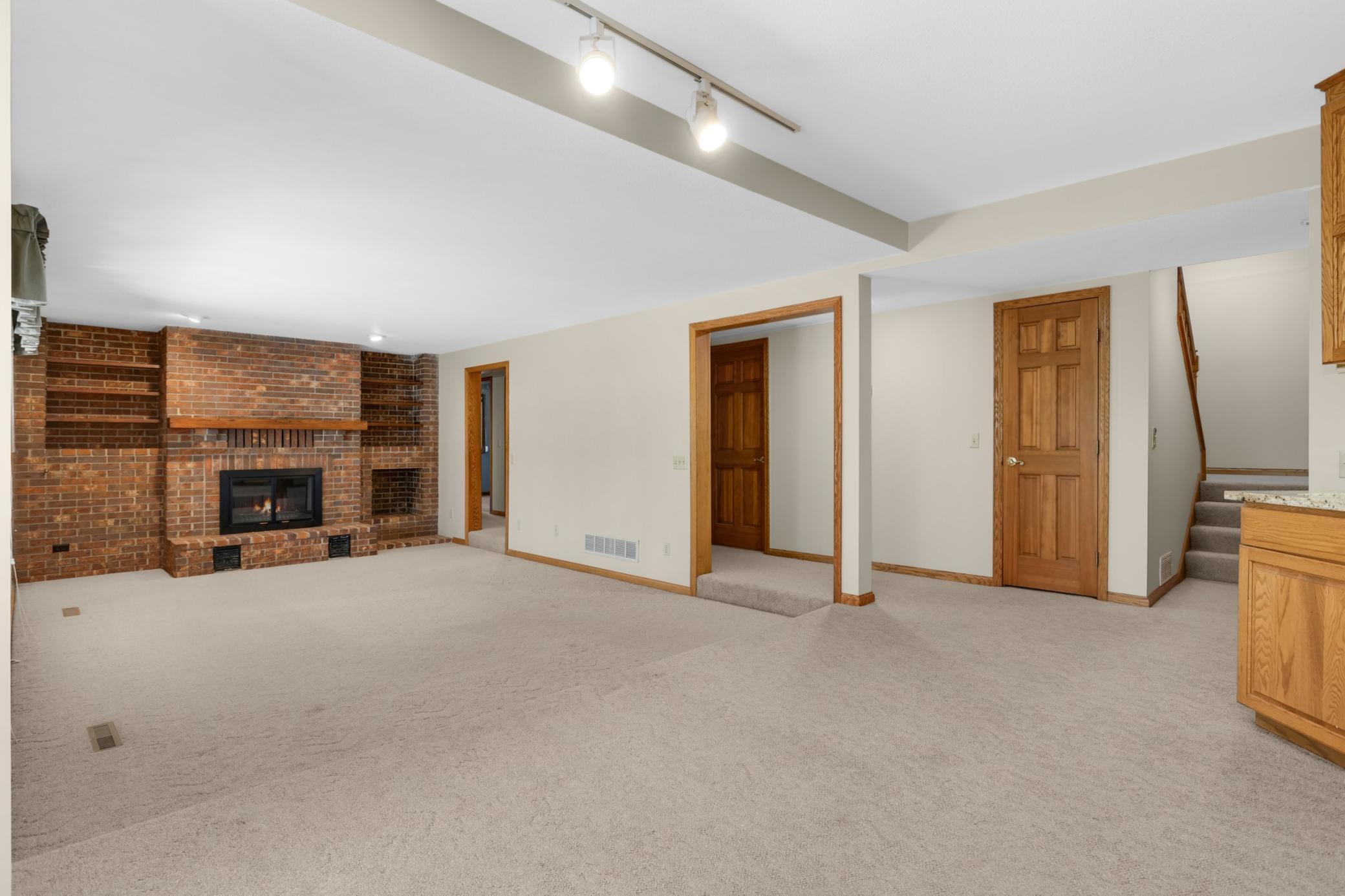 Large lower level family room with wood burning fireplace. A perfect place to entertain or relax on movie night!