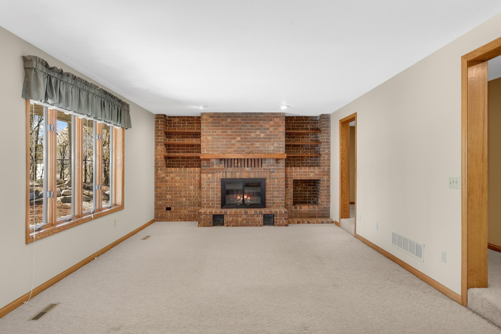 Lower level family room with wood burning fireplace and beautiful brickwork.