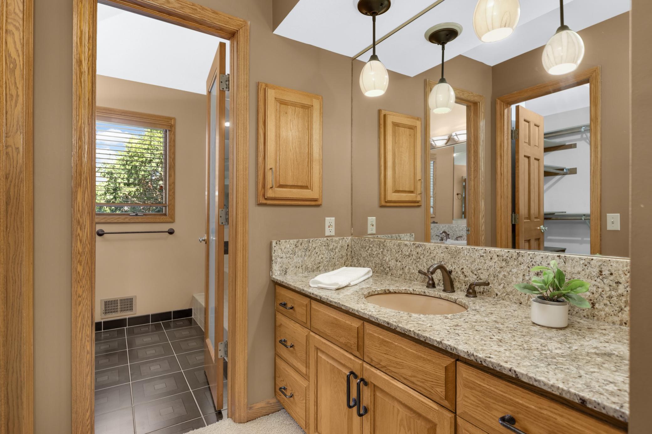 Primary bathroom with separate bathing and toilet area. Granite counters & quality woodwork.