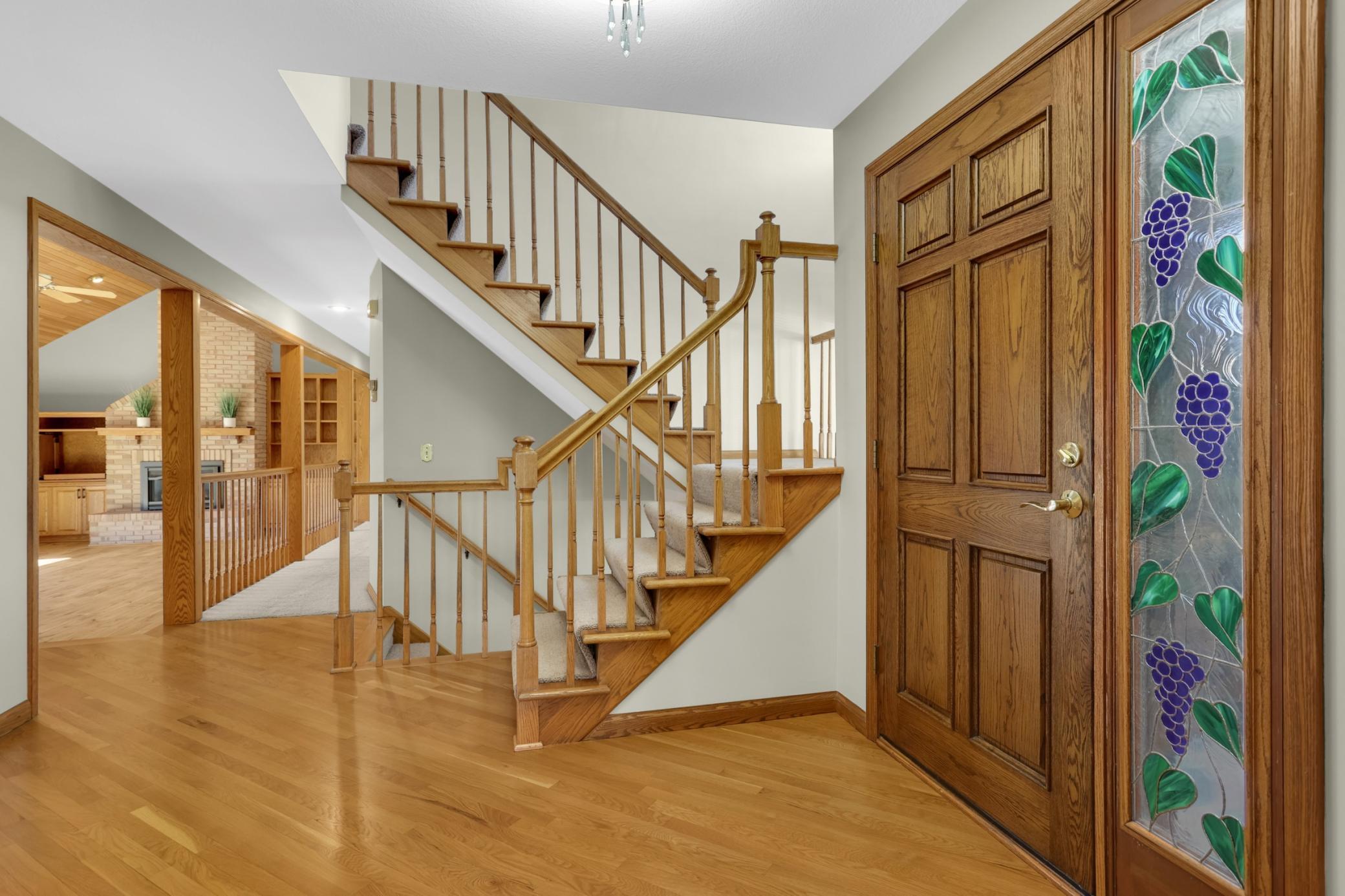 Large entry way with wood floors is the perfect spot to welcome your guests. Stairs lead to upper level loft and office area, lower stairs lead to full walkout lower level.