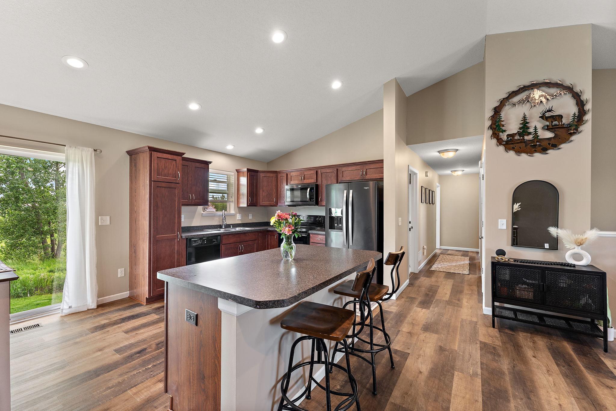 Larger kitchen, wall pantry, new flooring on main floor! Plus, pantry in the hallway! This kitchen has more floor space with the island located off to the side.