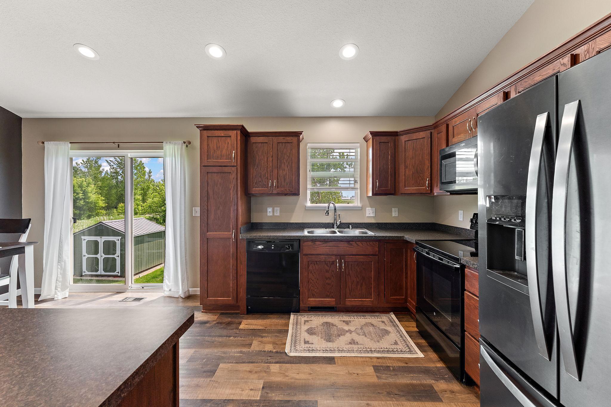 Kitchen window and patio door overlook the backyard