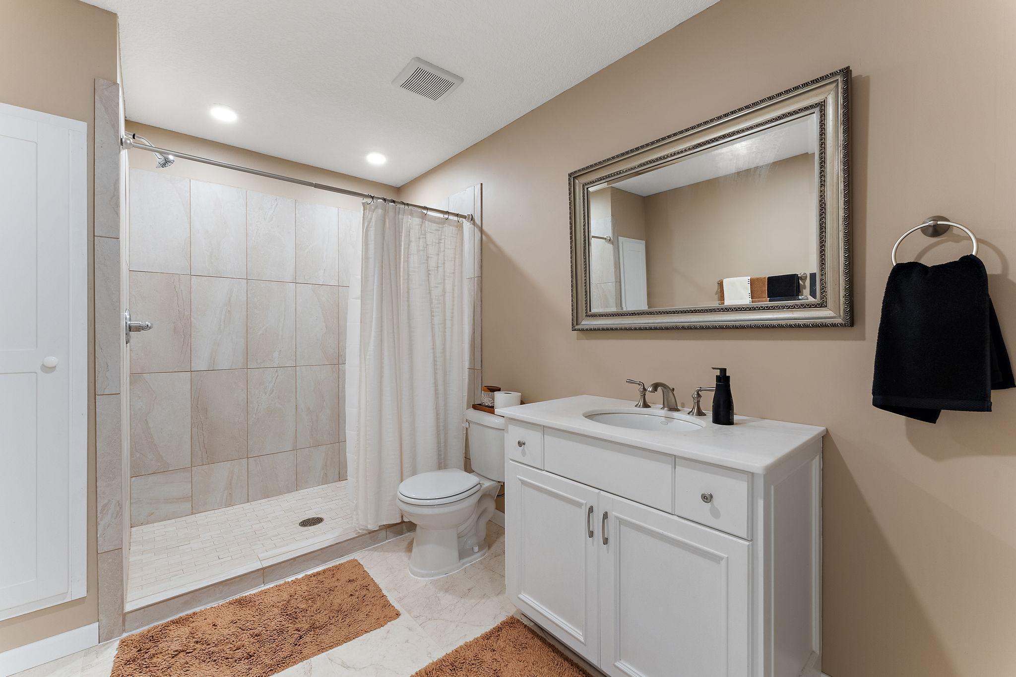 Lower level three-quarter bath has new flooring, tiled shower and linen cabinet.