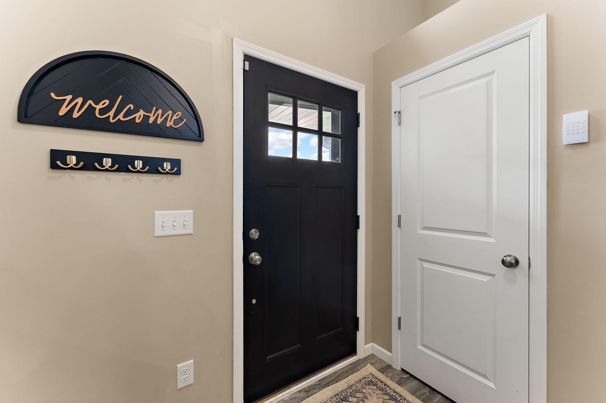 New entry flooring, coat closet and three-car garage door entrance.