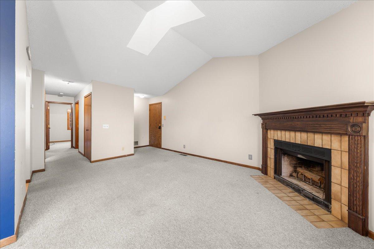 Living Room with wood burning fireplace and a skylight.