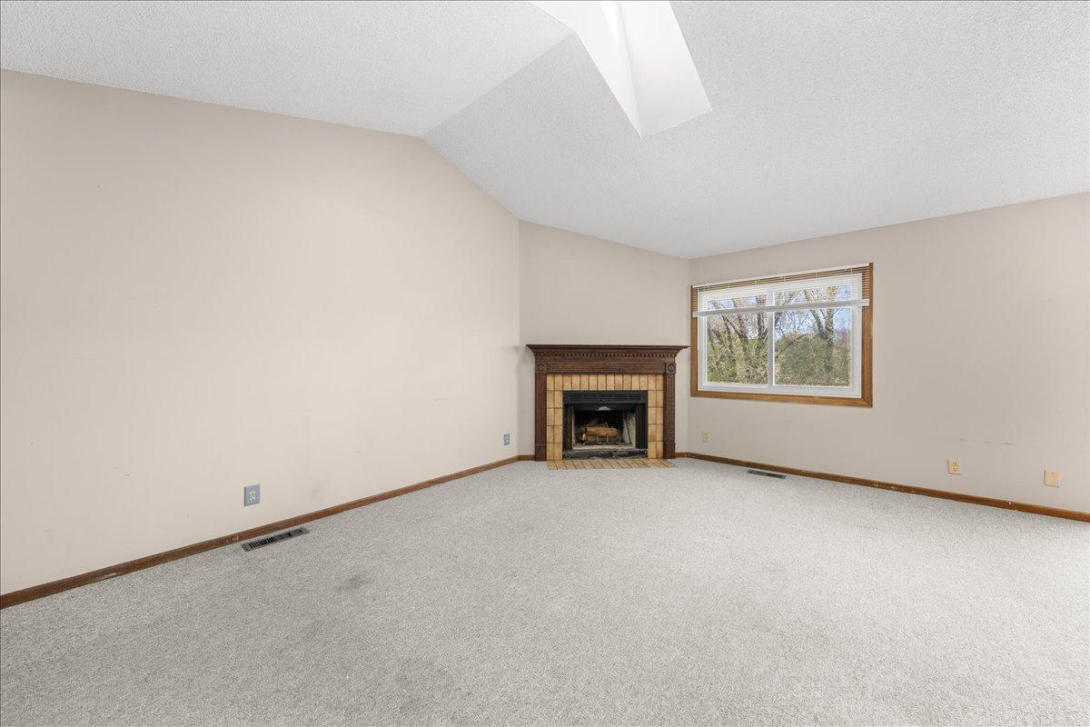 Spacious living room with wood burning fireplace.